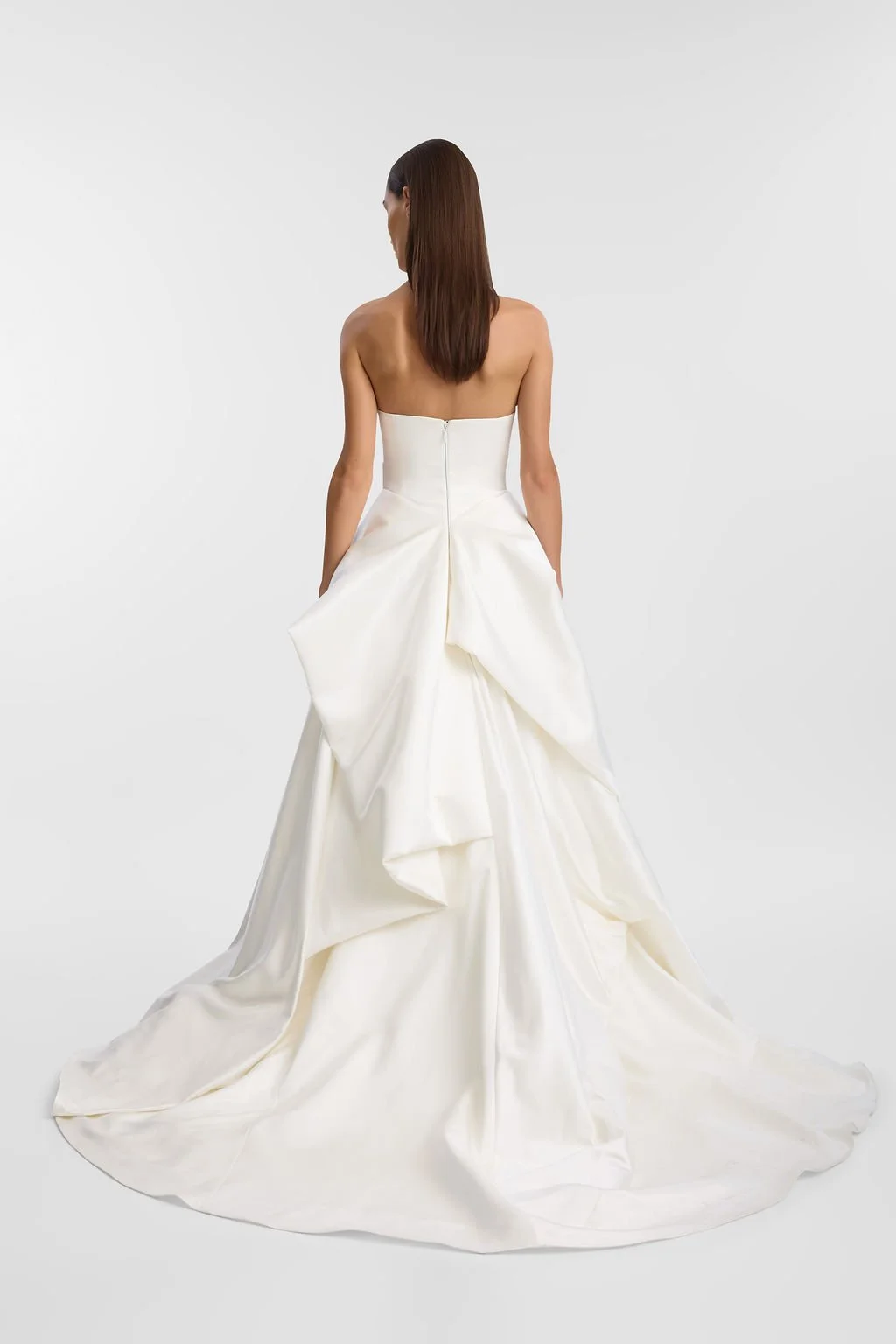 KYHA Bride Preston: an ode to eras past. A fresh take on tradition, Preston brings a modern edge thanks to its structural draping, showstopping train and architectural dropped waist. Crafted from luxe silk satin, Preston’s strapless silhouette, struc