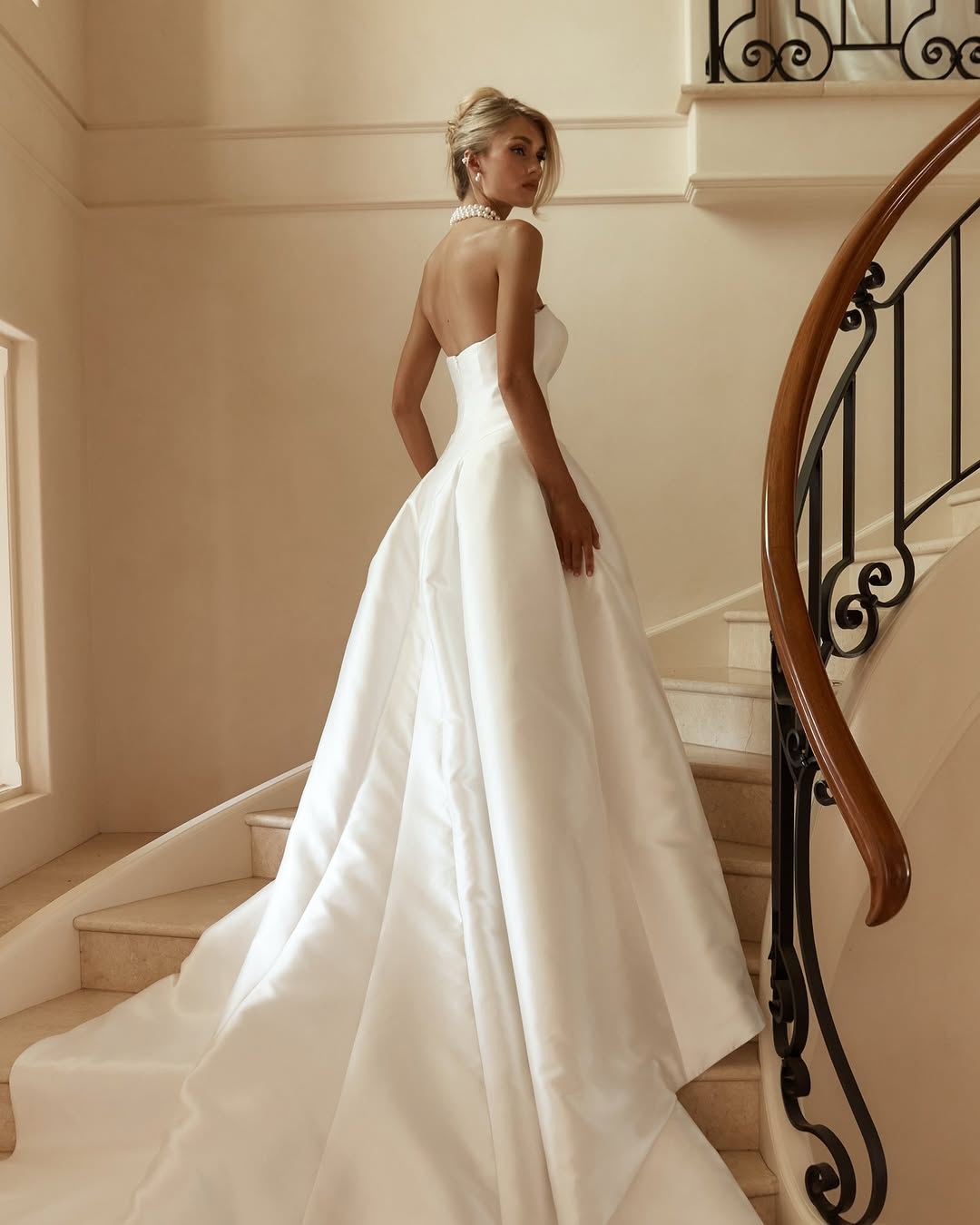 Jane Hill Bridal Dolce redefines regal with a sculptural rounded neckline and a seamless, panelled bodice that melts into the skirt. designed to elongate the figure, this minimalist silhouette features a hidden back zip for a clean finish.