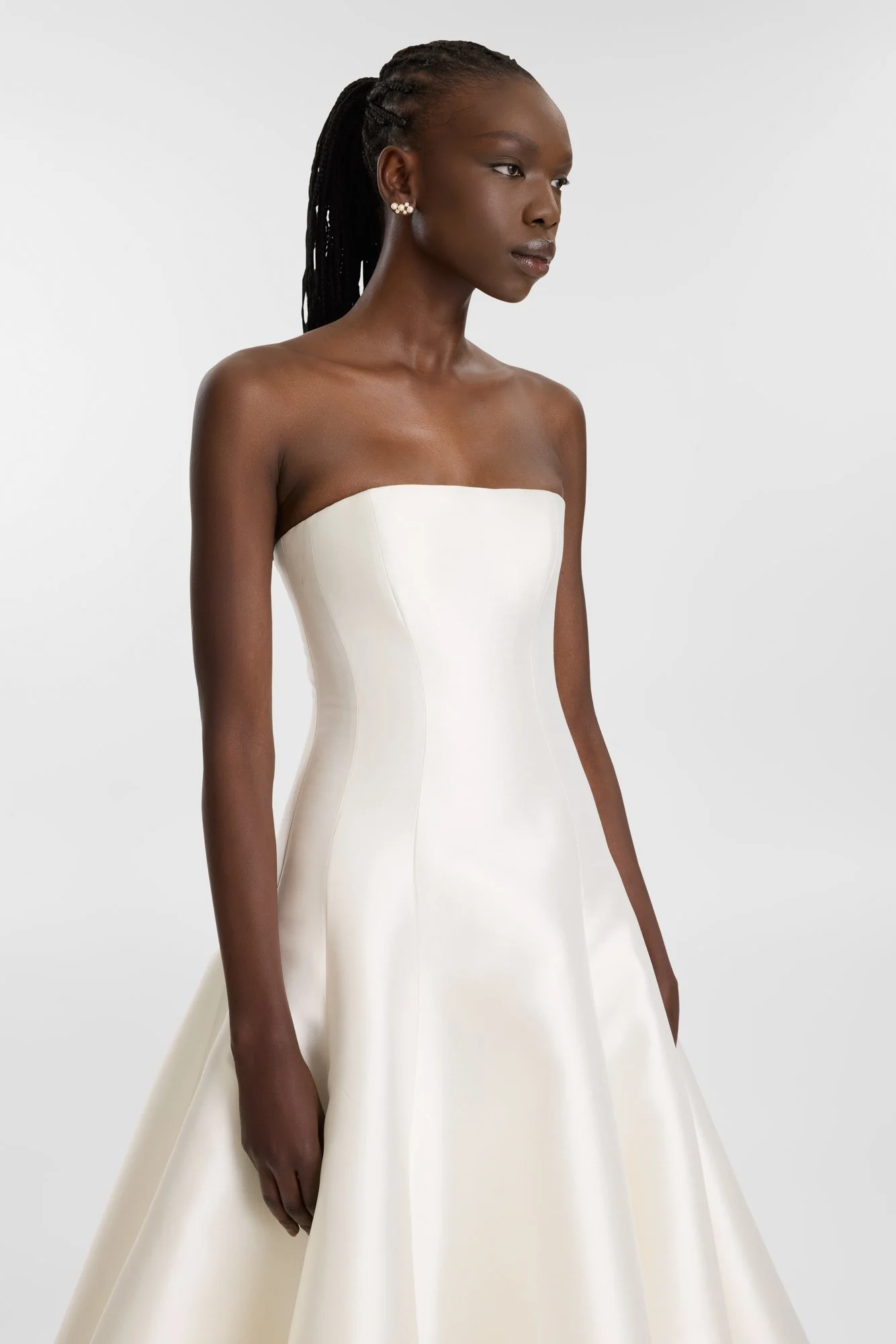 Contemporary couture meets nostalgic nuance in KYHA Bride Adler. Architectural in form yet fluid in movement, this strapless gown is cut from lustrous Mikado holds its sculptural shape. A clean, straight neckline sets creates a modern edge, while the
