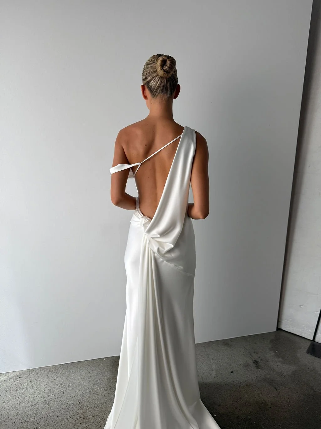 Effortlessness takes the lead in KYHA Bride Arlo. Cut on the bias, liquid double satin falls naturally over the body, delivering nonchalant energy with a distinctly modern edge. A clean, minimal off-shoulder front allows the open back to take centre 