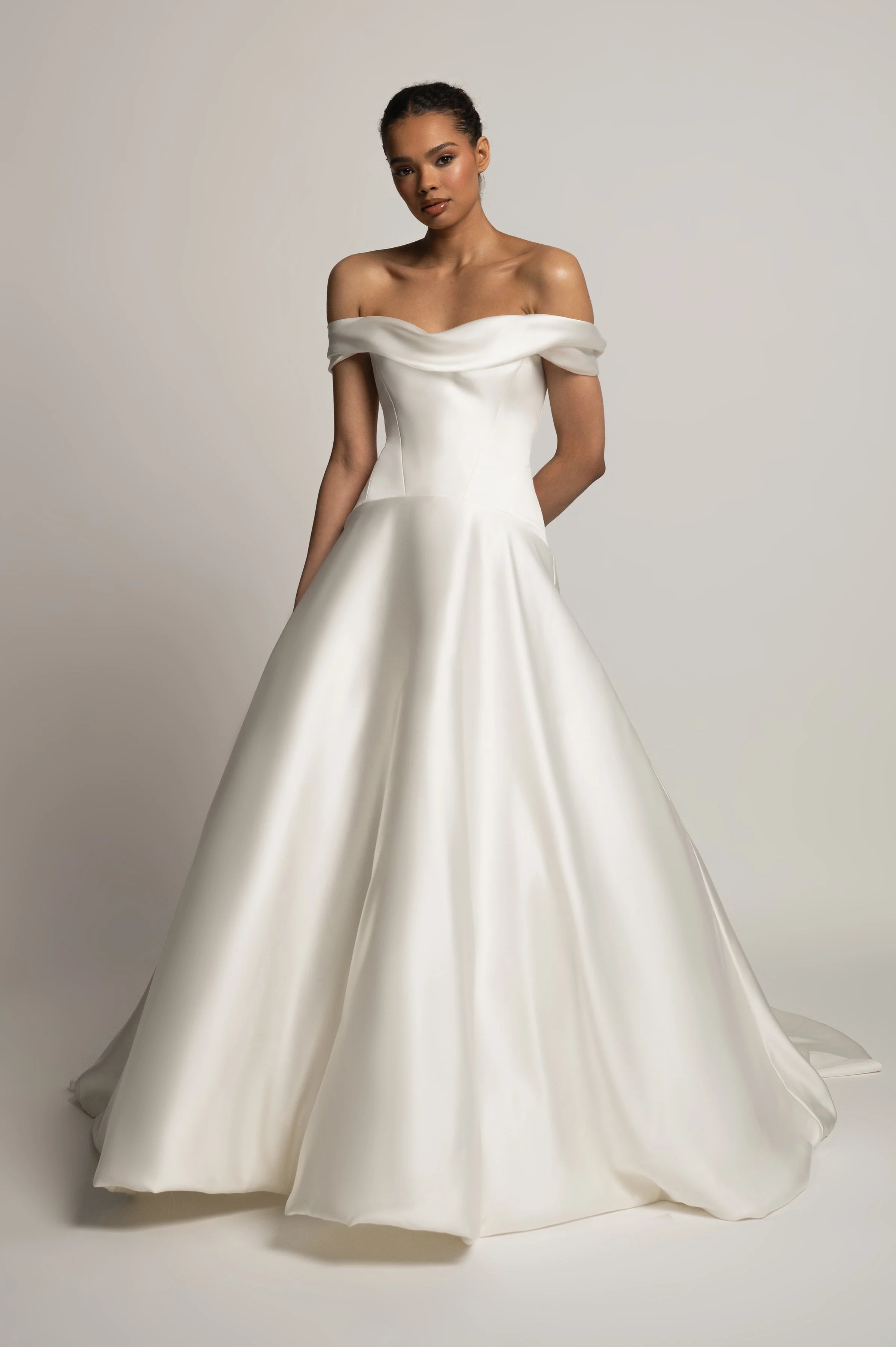 The Jenny Yoo Bridal Greer gown, our second collaboration with renowned bridal stylist, Hope LaVine, is as modern as she is timeless. Featuring a softly draped off the shoulder neckline, angled corset seam details, and a curved drop waist, she is stu