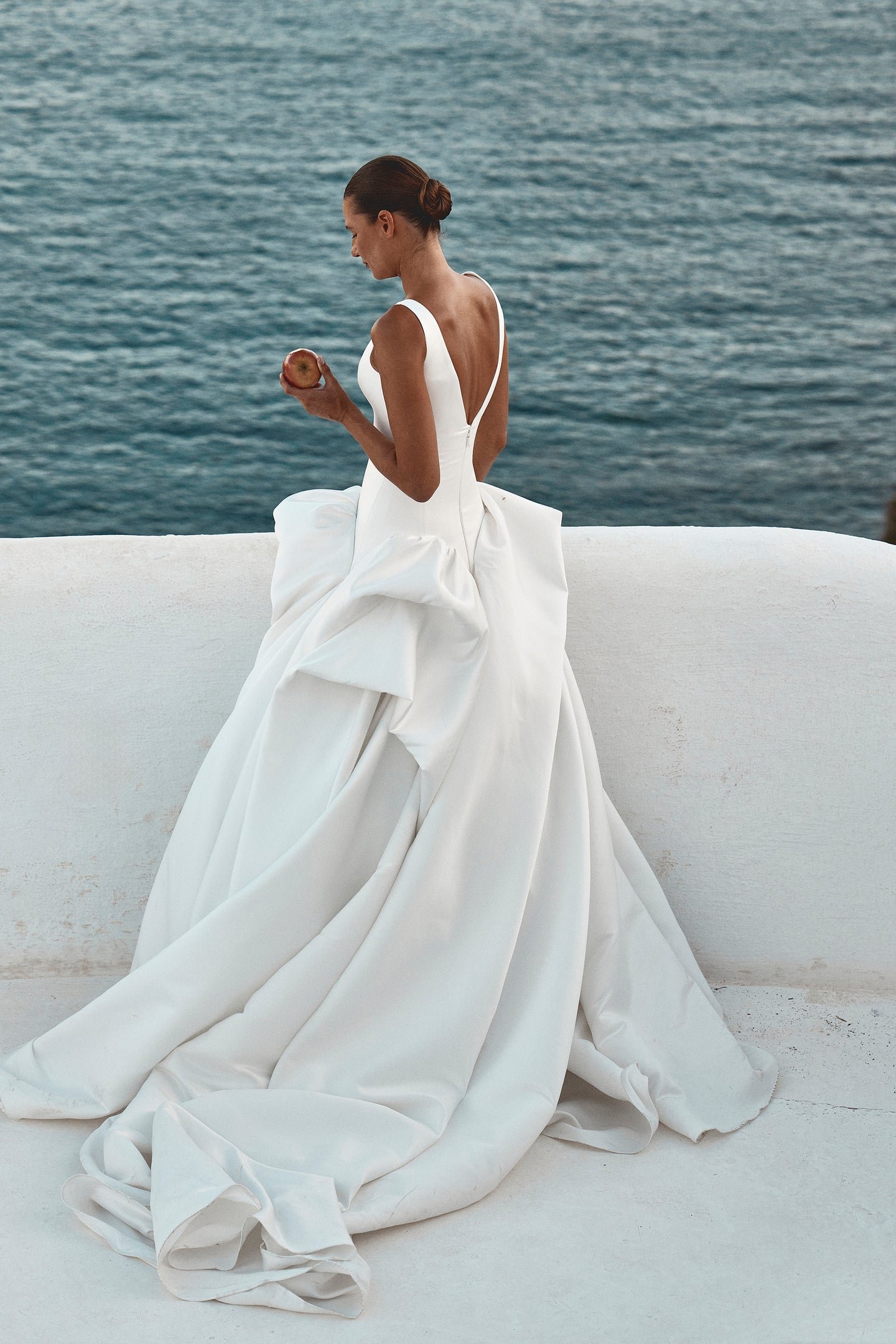 Drama takes shape in KYHA Bride Bailey at Halo + Wren. A directional take on the classic ballgown, Bailey is crafted from lustrous duchess satin and defined by artfully placed, architectural draping. Sculptural folds play with light and bring dimensi
