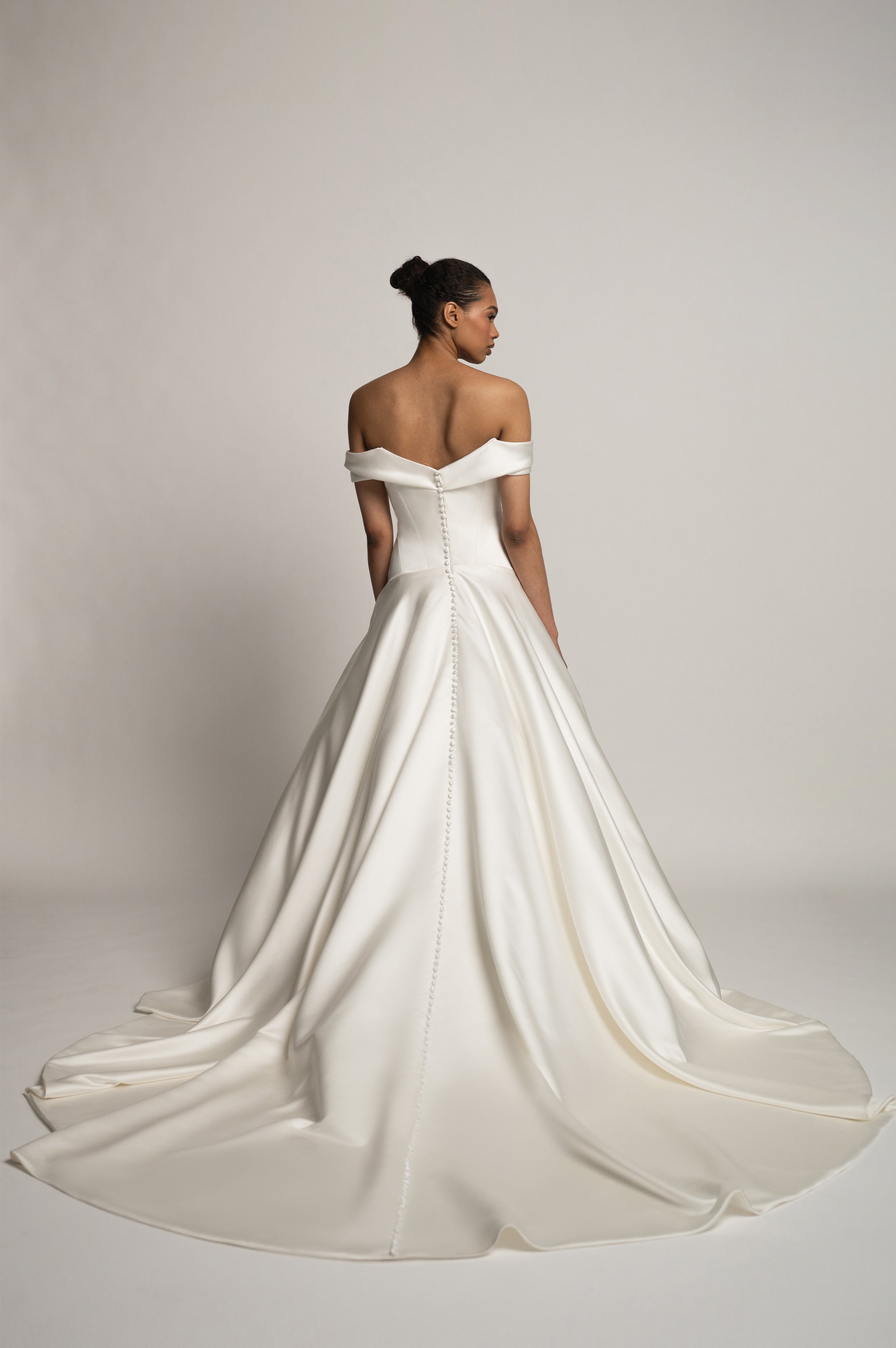 The Jenny Yoo Bridal Greer gown, our second collaboration with renowned bridal stylist, Hope LaVine, is as modern as she is timeless. Featuring a softly draped off the shoulder neckline, angled corset seam details, and a curved drop waist, she is stu