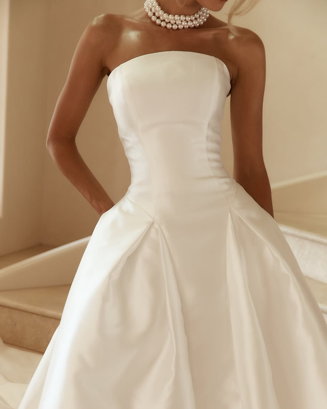 Jane Hill Bridal Dolce redefines regal with a sculptural rounded neckline and a seamless, panelled bodice that melts into the skirt. designed to elongate the figure, this minimalist silhouette features a hidden back zip for a clean finish.