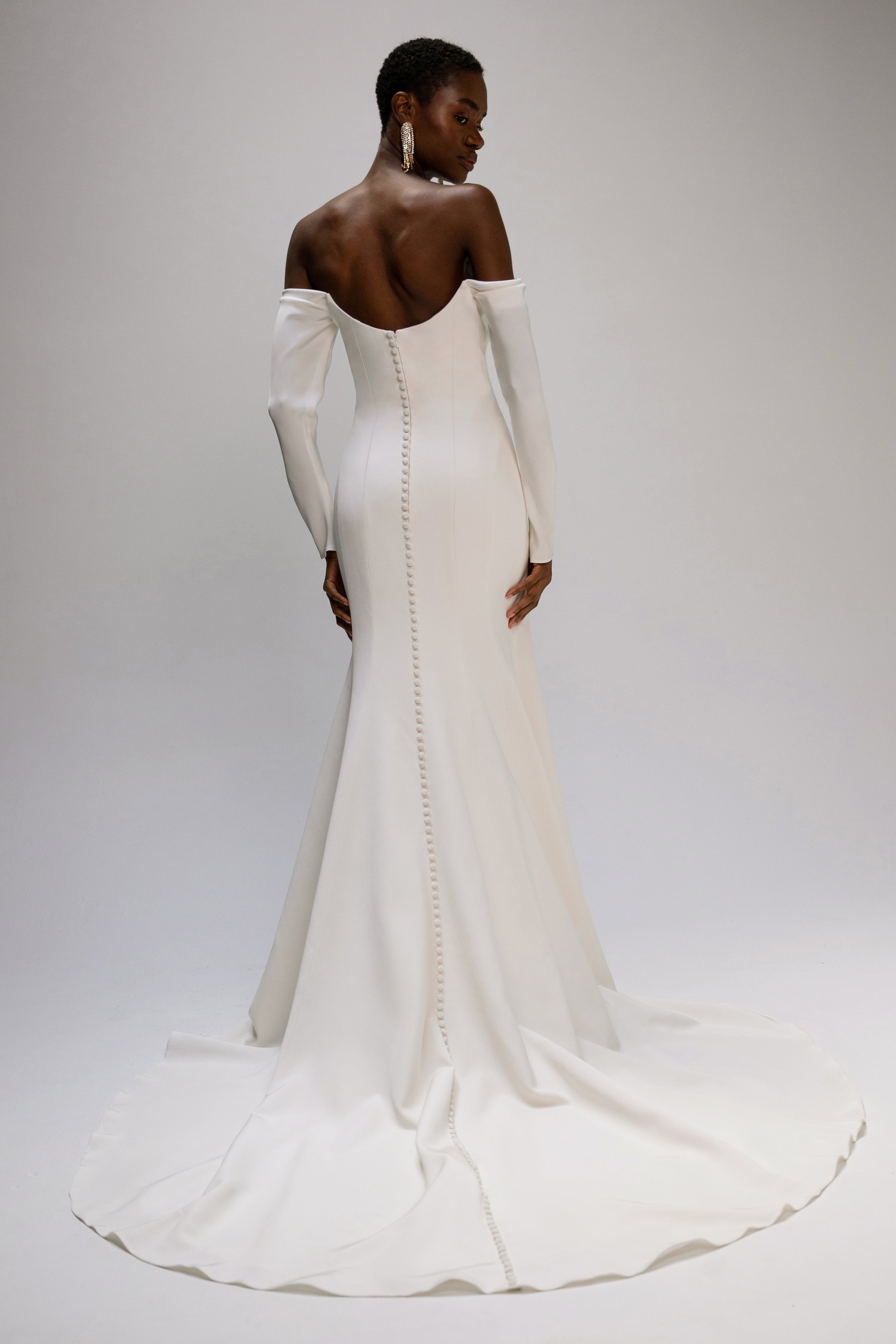 The Jenny Yoo Briar gown is a sophisticated fit-and-flare bridal dress in lustrous silk crepe with a softly draped empire bodice that flatters the décolletage and highlights the shoulders. It features long, slim sleeves and an off-the-shoulder or ele