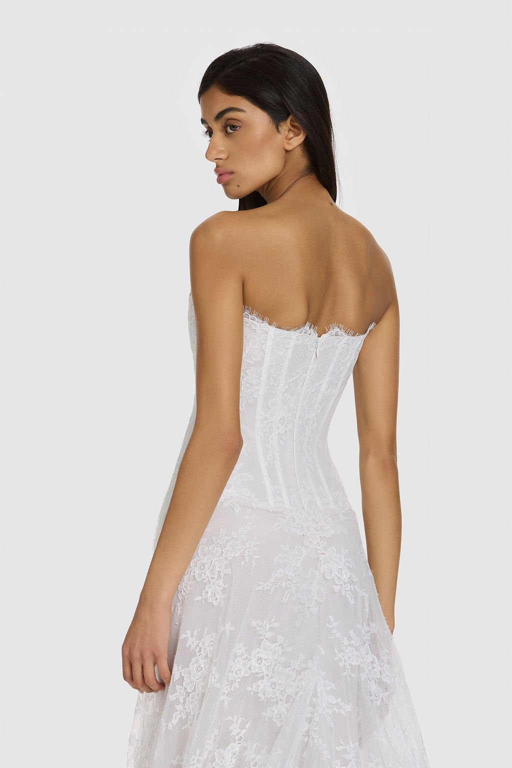 Quiet drama reimagined in KYHA Bride Mimi. Lace without the noise, Mimi's silhouette is deliberately spare. A structured, strapless corset sees sheer lace panels layer over chiffon, casting soft contrast against warm shell for a fresh yet understated