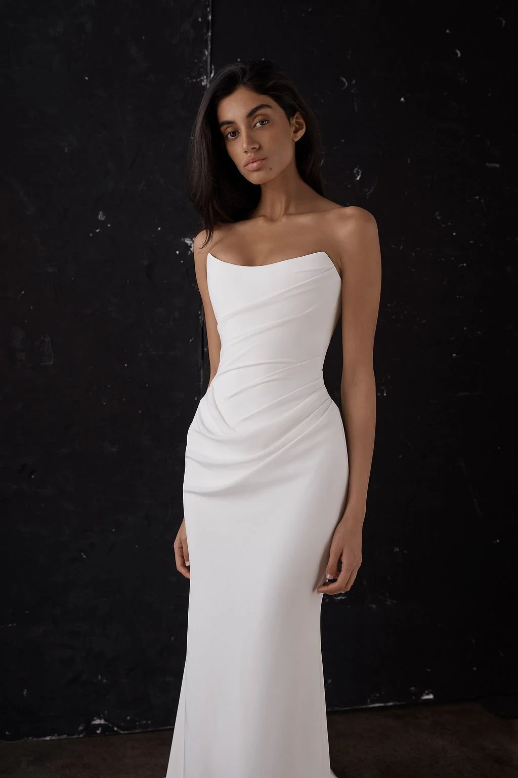 Draping becomes an art form in Archer. Crafted from a matte triacetate, a structured, scoop neckline bodice cinches the waistline and a fit and flare skirt celebrates the female form. But the star of the showstopping Archer gown is its draping. Tight