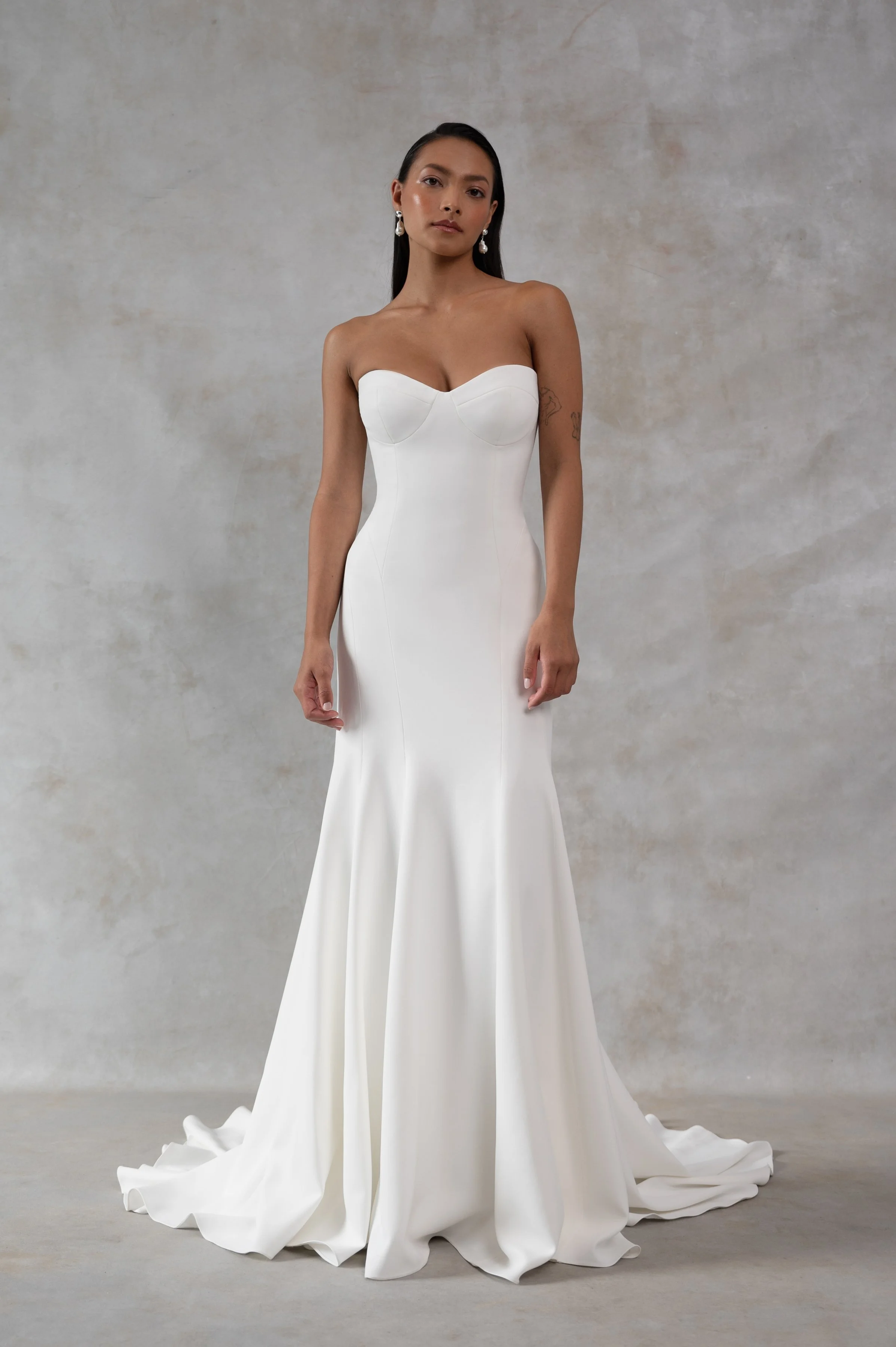 The Jenny Yoo Bridal Geeta gown is a classic bombshell. Cut in our favorite body-hugging Italian crepe, she features curve enhancing seam details and a structured bustier bodice.