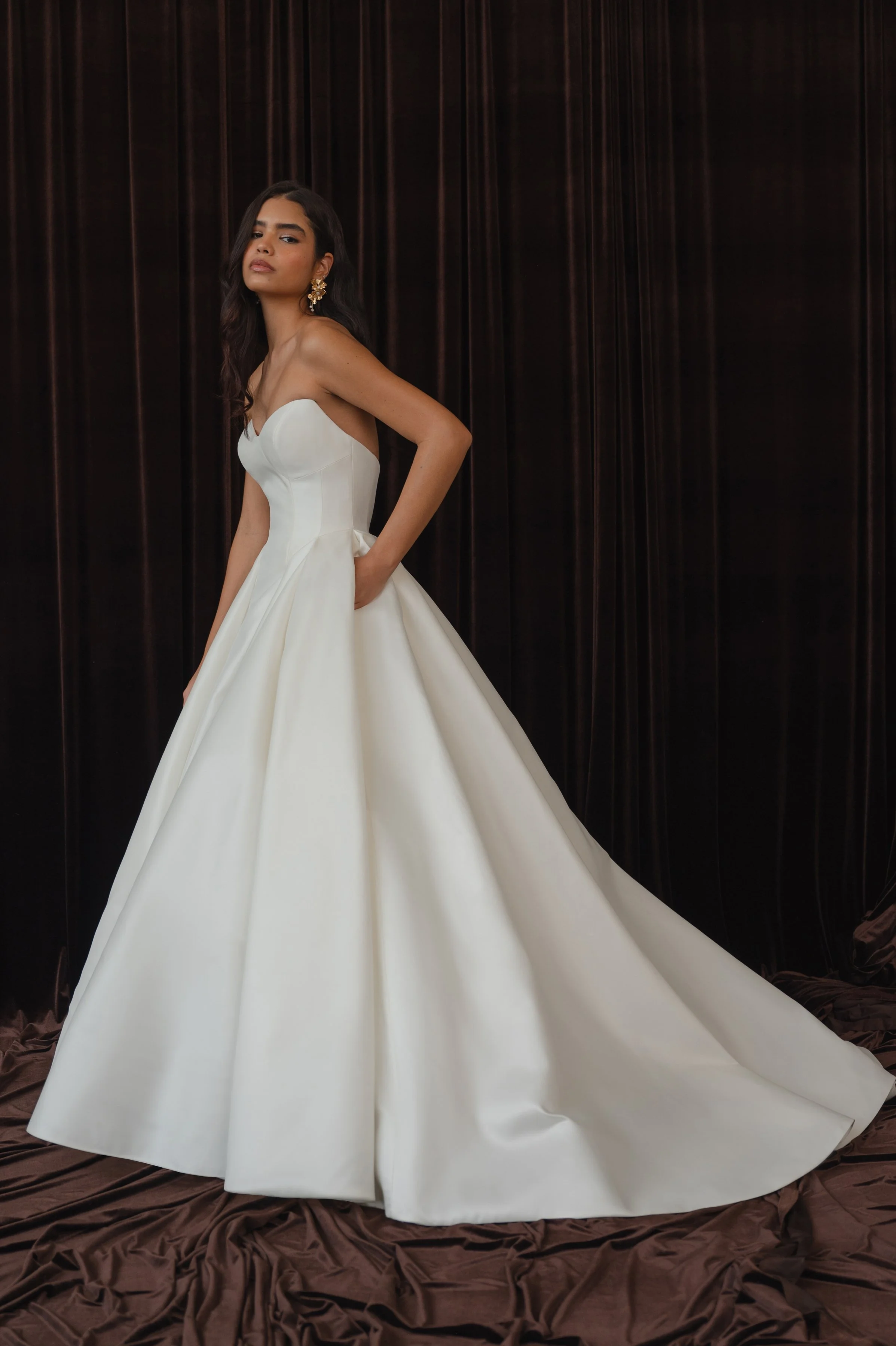 The Jenny Yoo Bridal Colette gown, cut in our light and lustrous Italian taffeta fabric is a clean, yet striking show stopper. Intricate seam details sculpt a bustier bodice and subtle drop waist silhouette. Pleats in the ball skirt create dramatic v