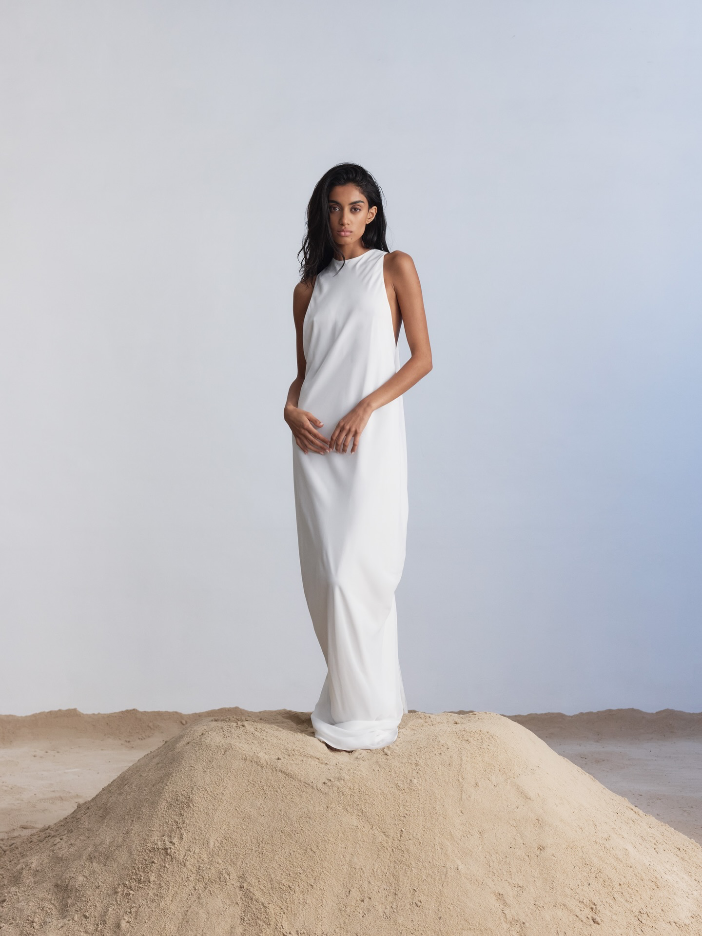Floating on Air(eys). Rethinking the code of tradition, Aireys is defined by movement thanks to its open draped back that falls away from the body, gathering in a dramatic knot and extending into a train that descends from the knot into a soft puddle