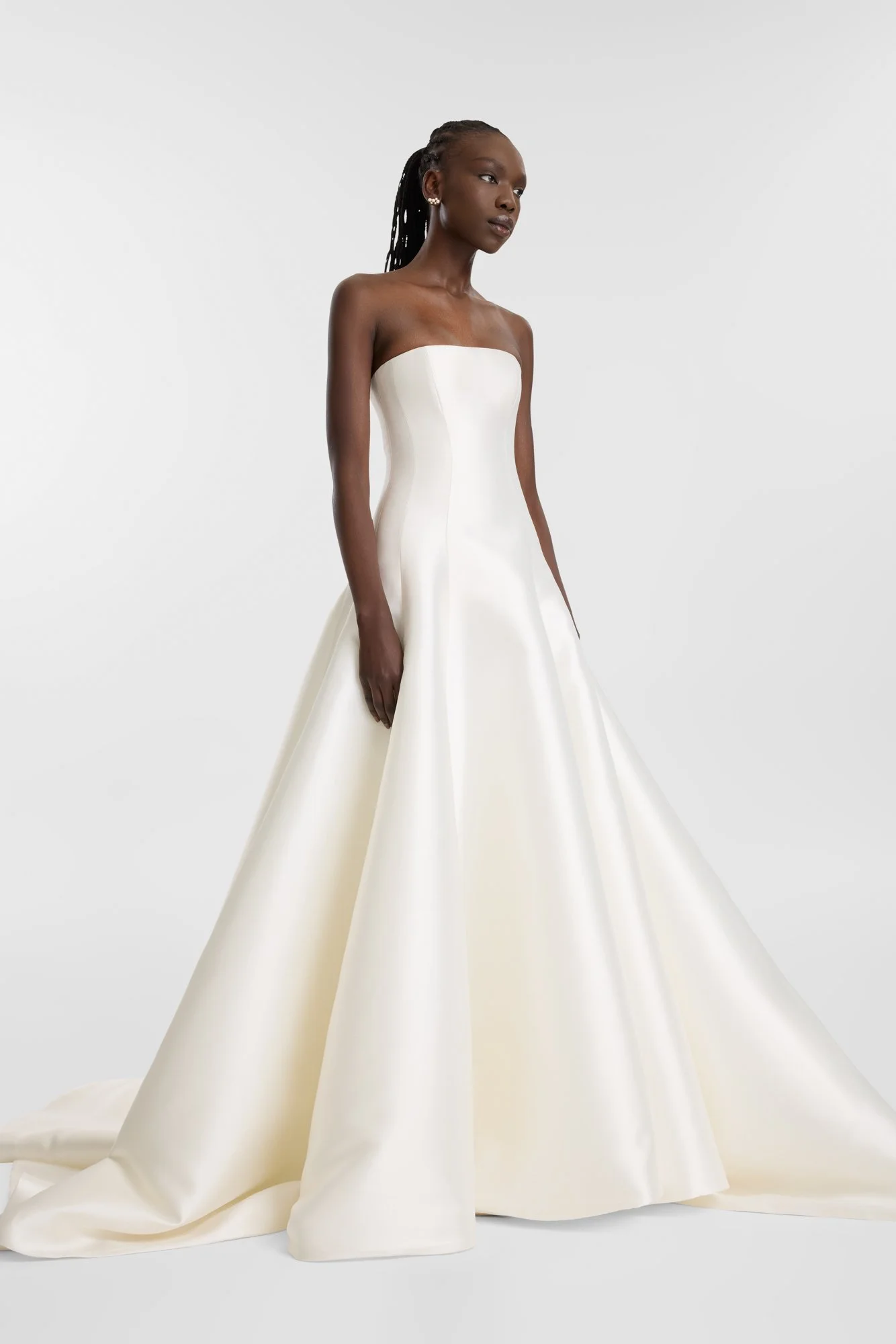 Contemporary couture meets nostalgic nuance in KYHA Bride Adler. Architectural in form yet fluid in movement, this strapless gown is cut from lustrous Mikado holds its sculptural shape. A clean, straight neckline sets creates a modern edge, while the