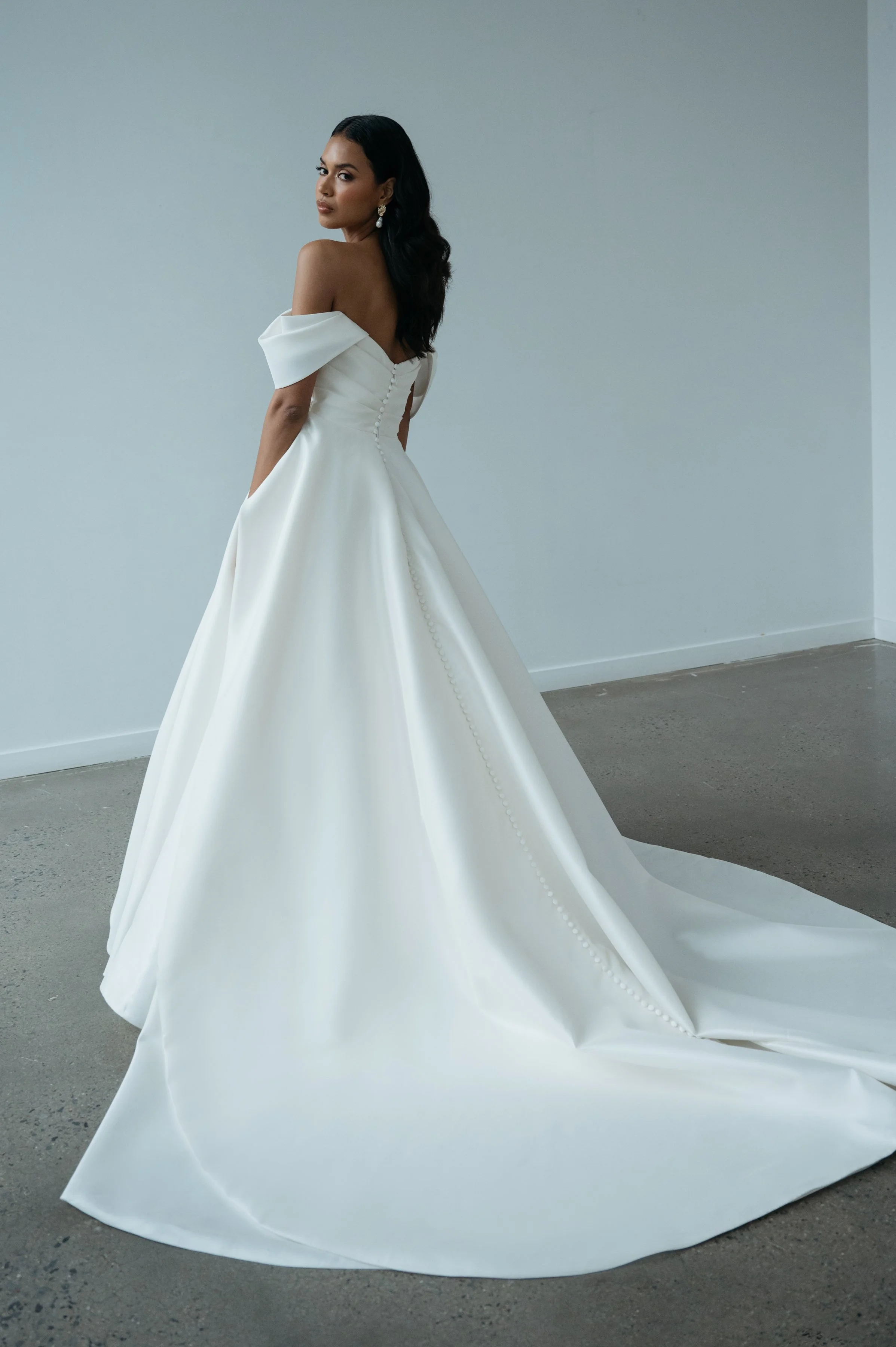 The Jenny Yoo Bridal Gardenia gown  is a refined, minimalist satin design with a clean, structured bodice and effortless drape. It features a flattering neckline and a sleek, flowing skirt that creates a modern yet timeless bridal silhouette.