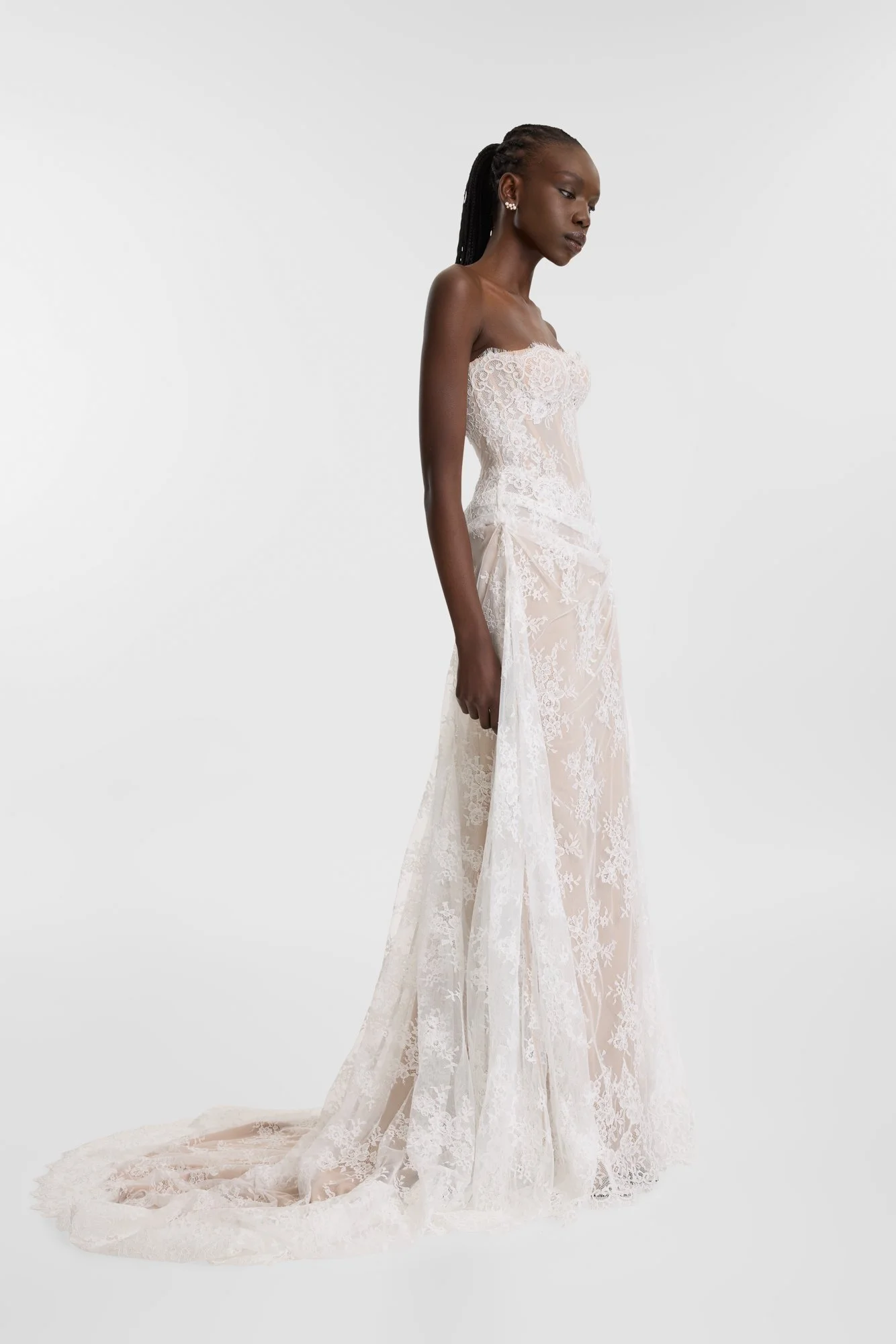 Diaphanous dressing in KYHA Bride Wilton. Constructed by hand-moulding delicate lace, Wilton sees swathes of sheer lace contrast a nude chiffon base for a study in understated impact. A highly structured, corseted bodice boasts a scalloped edge along