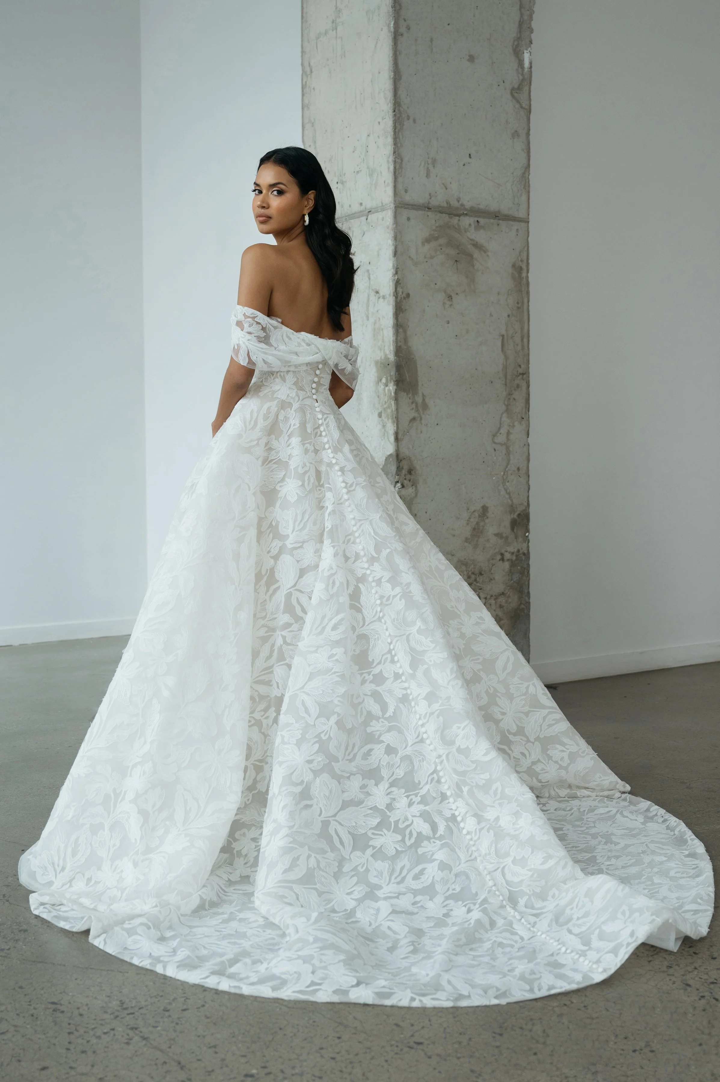 The Jenny Yoo Ezra gown is an ethereal ball gown that feels as though it floats on air, crafted in intricate Iris cutwork tulle over a dramatic crinoline skirt that’s diaphanous and light. It features a fully corseted, flattering bodice and comes wit
