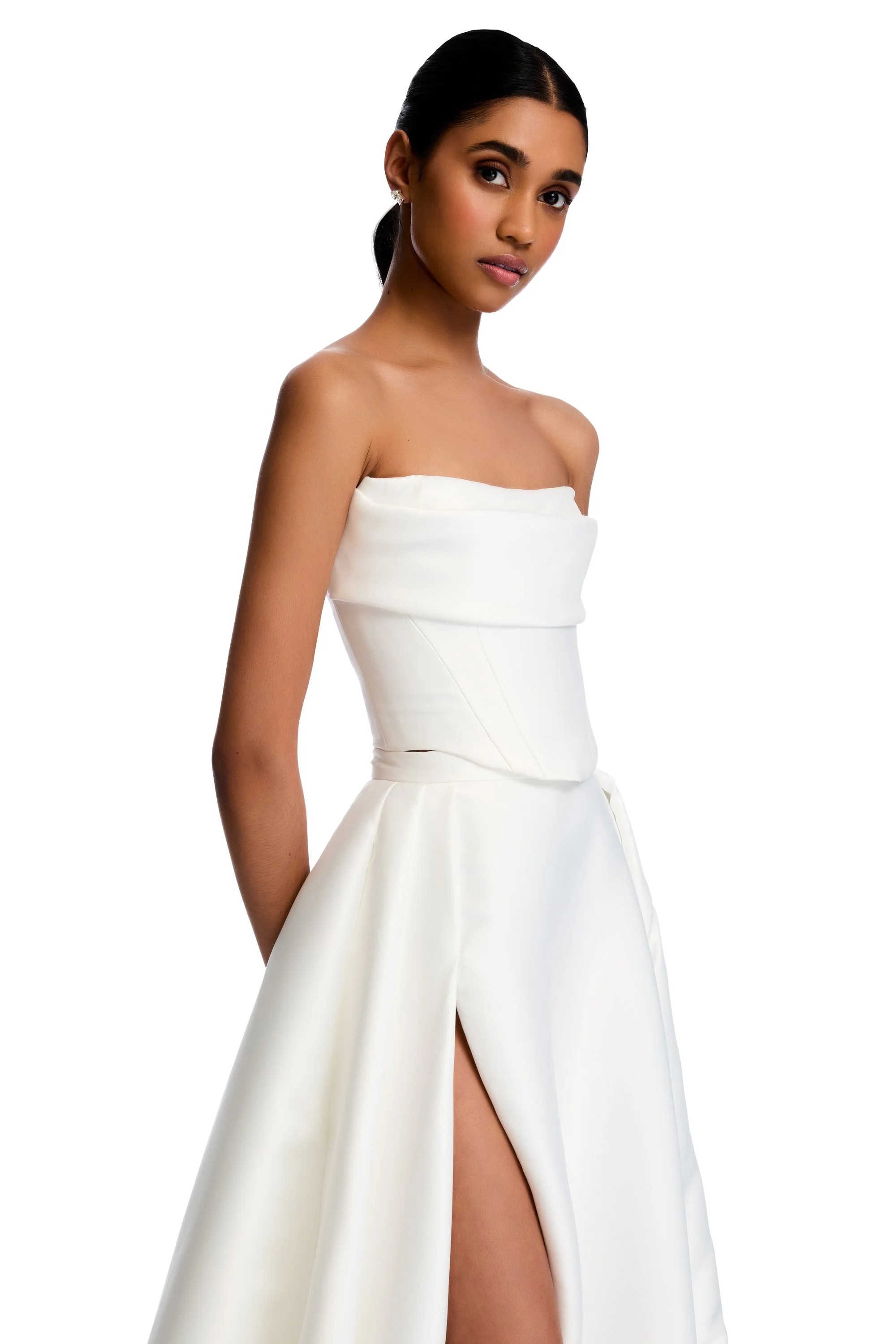 Be followed by a train of lustrous duchess satin every step you take with the KYHA Bride Milford Skirt. With a fitted waistband and full pleated skirt with a modern split, the Milford Skirt can be styled as an overskirt to raise the drama of any look