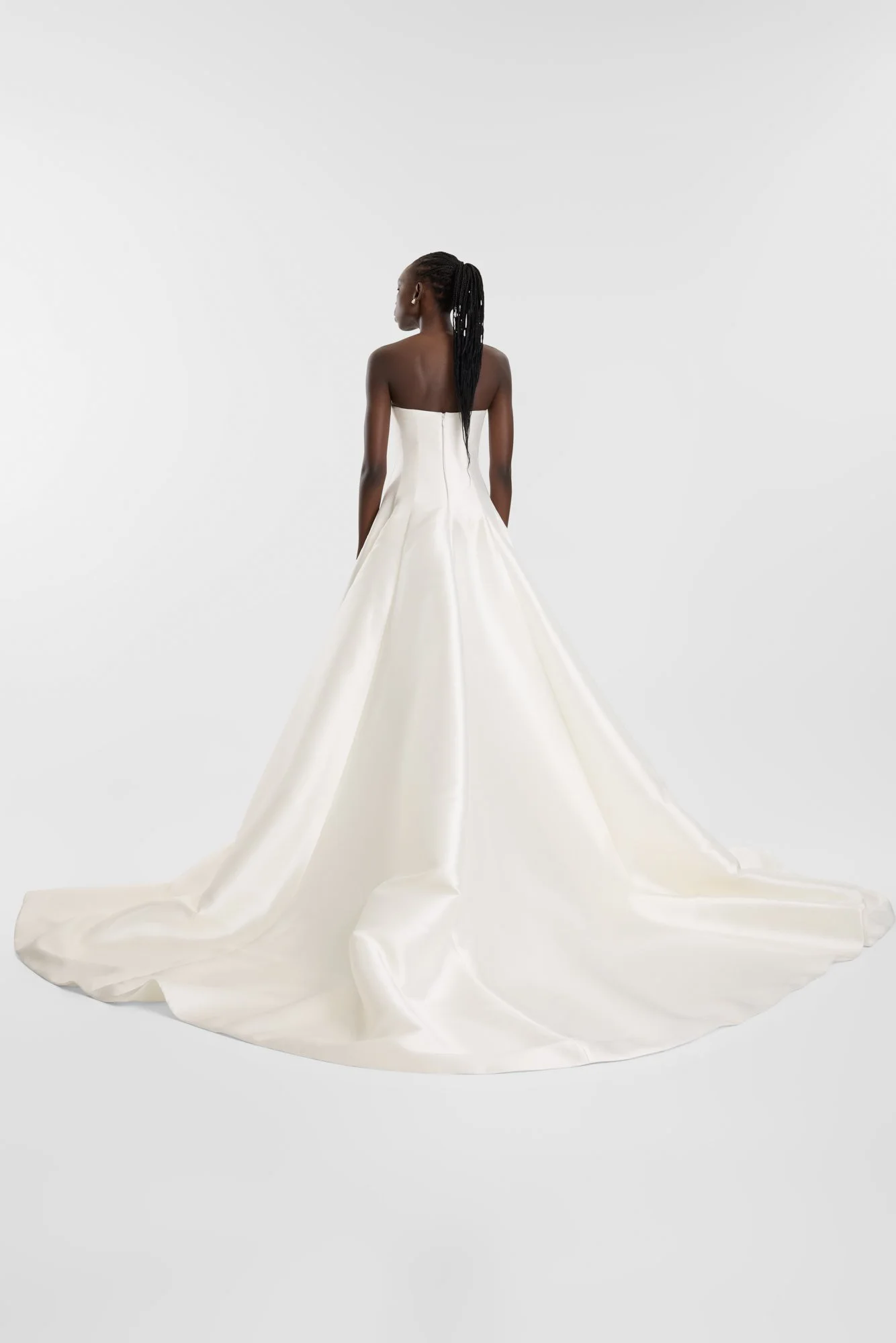 Contemporary couture meets nostalgic nuance in KYHA Bride Adler. Architectural in form yet fluid in movement, this strapless gown is cut from lustrous Mikado holds its sculptural shape. A clean, straight neckline sets creates a modern edge, while the