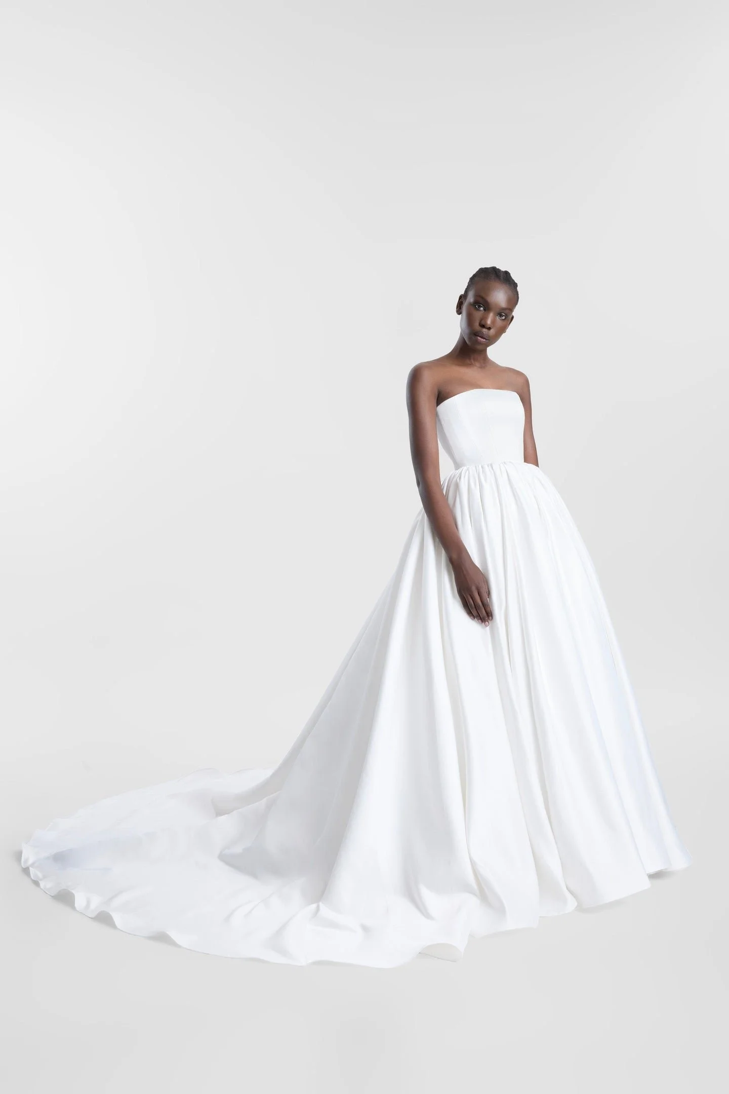 Clean lines, dramatic proportions and more than a touch of je ne sais quoi define KYHA Bride Cleo. A minimalist reinvention of the traditional ballgown, Cleo's clean, strapless bodice is defined by a modern straight neckline and unexpected low-dipped