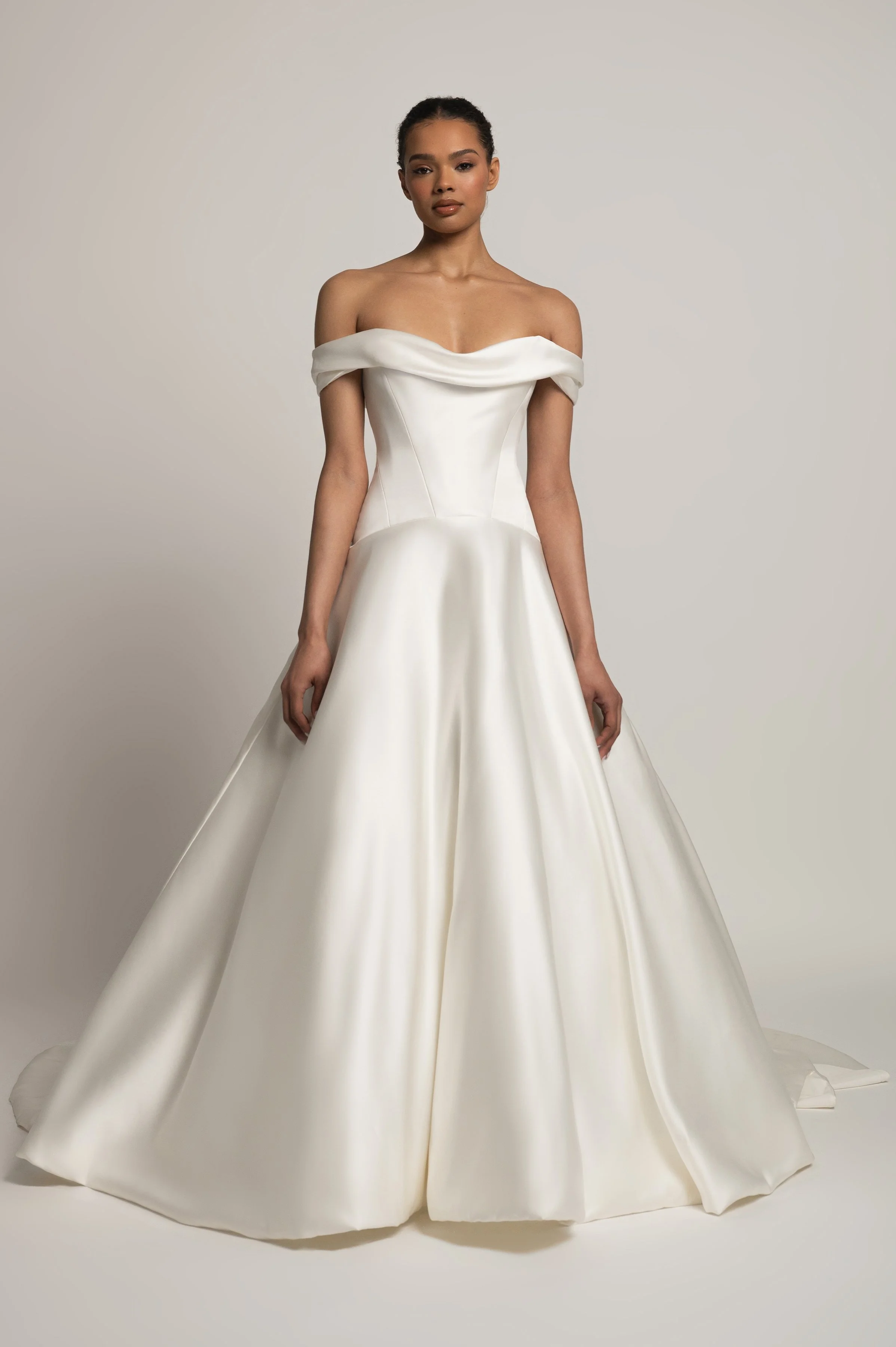 The Jenny Yoo Bridal Greer gown, our second collaboration with renowned bridal stylist, Hope LaVine, is as modern as she is timeless. Featuring a softly draped off the shoulder neckline, angled corset seam details, and a curved drop waist, she is stu