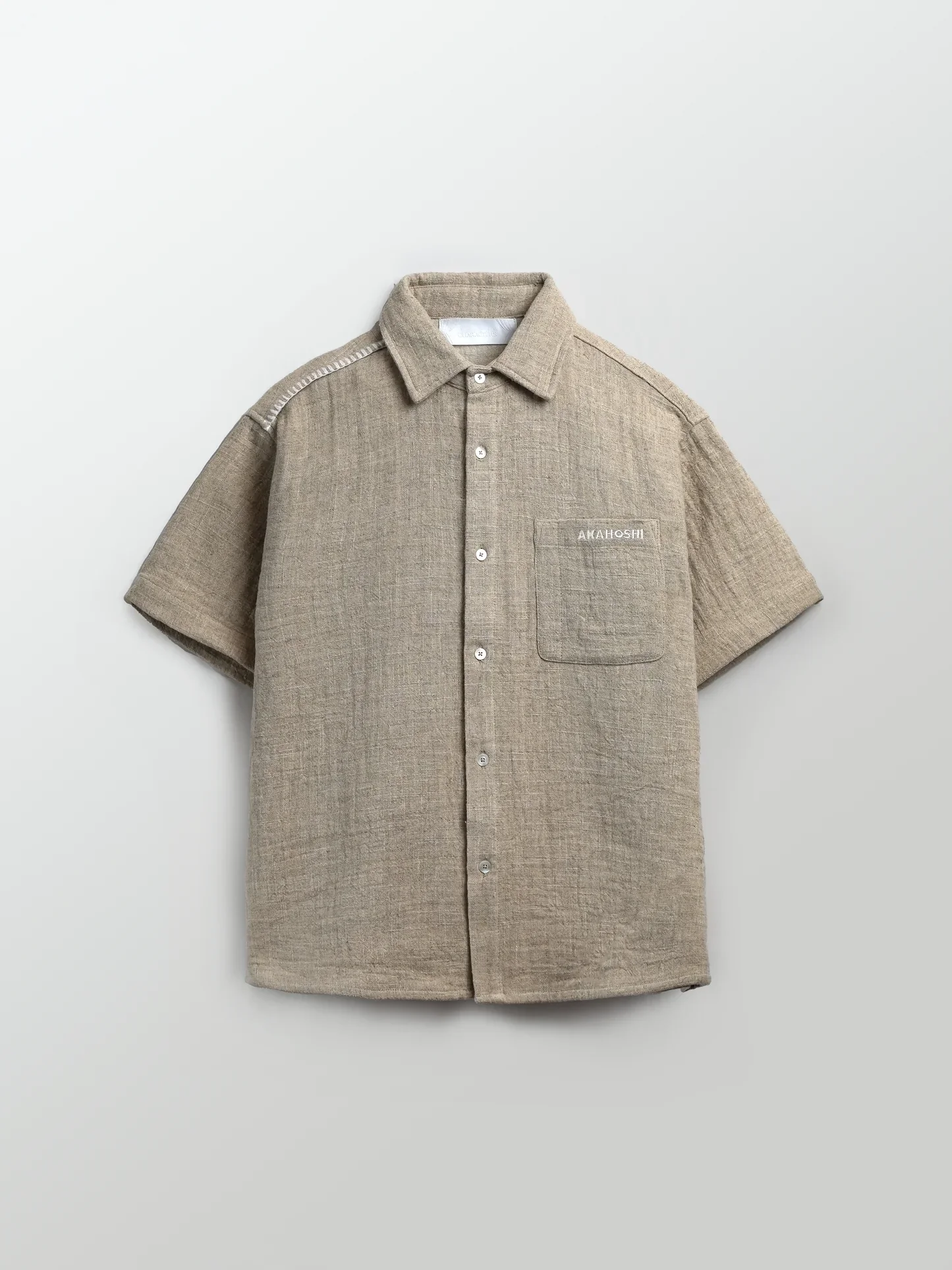 Akahoshi x Hidden Characters Work Shirt
Smock style button up designed with kitchen heat resistance and freedom of movement in mind. Textured linen with a rugged hand feel. Bamboo colorway. 
$98