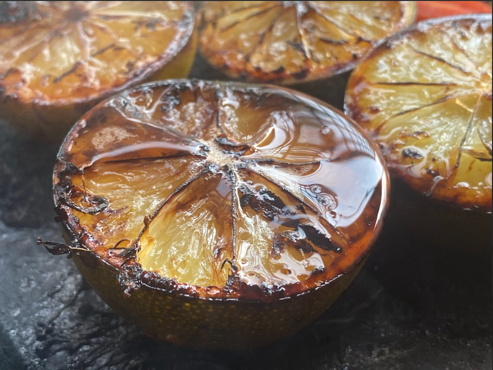 Close-up of grilled lemon halves on a cooking surface