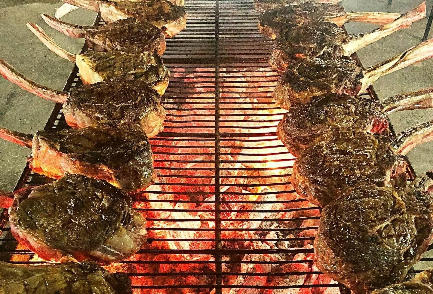 Grilled tomahawk steaks over open flames