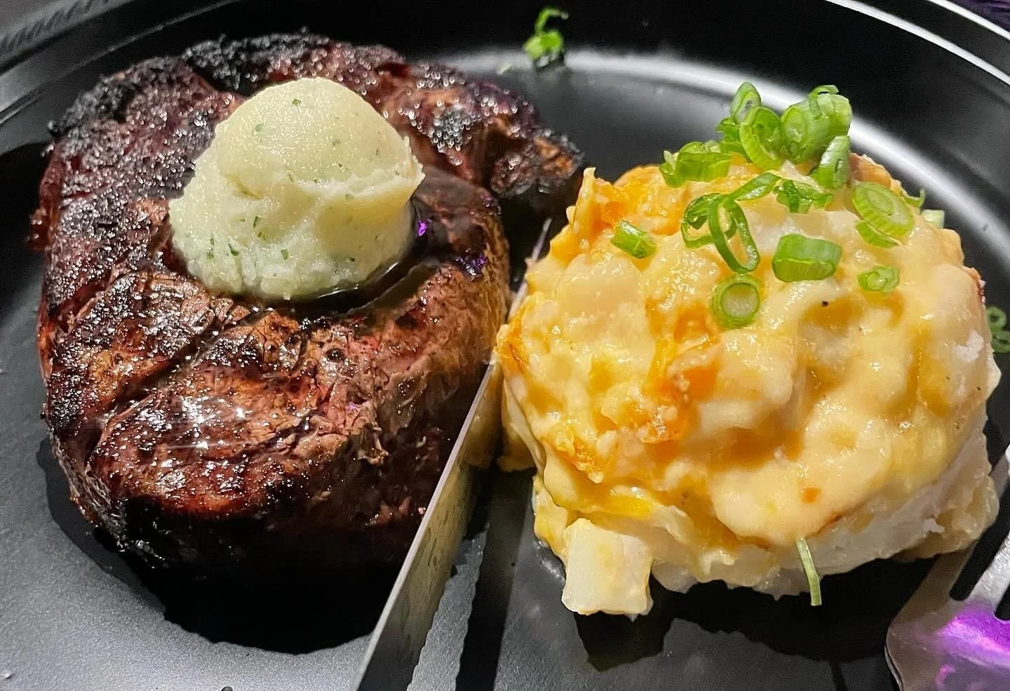 grilled steak topped with herb butter, paired with creamy, cheesy potatoes by Southern Standard Catering, Houston.
