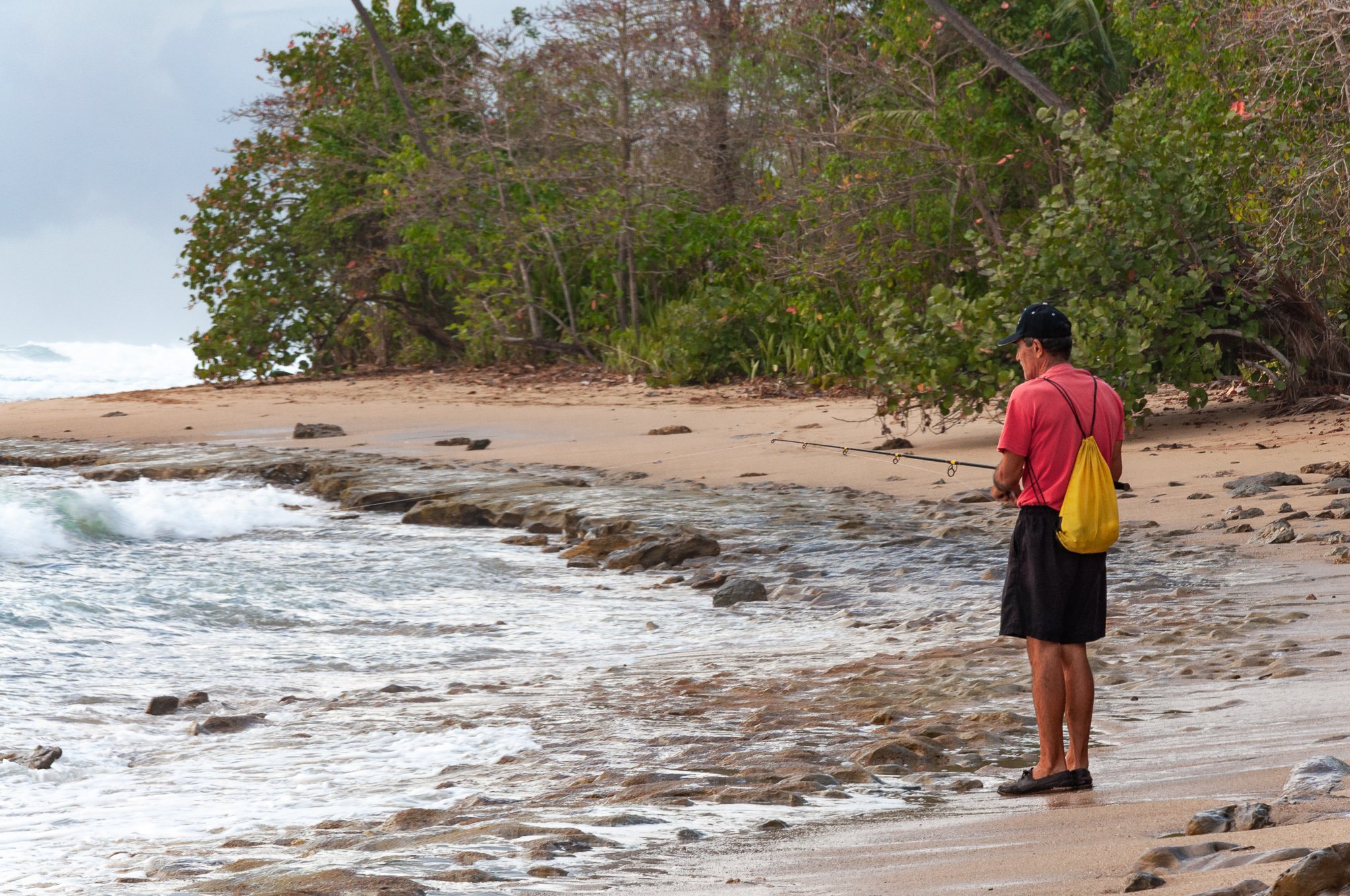 man fishing rough waters in Rincon, Puerto Rico.