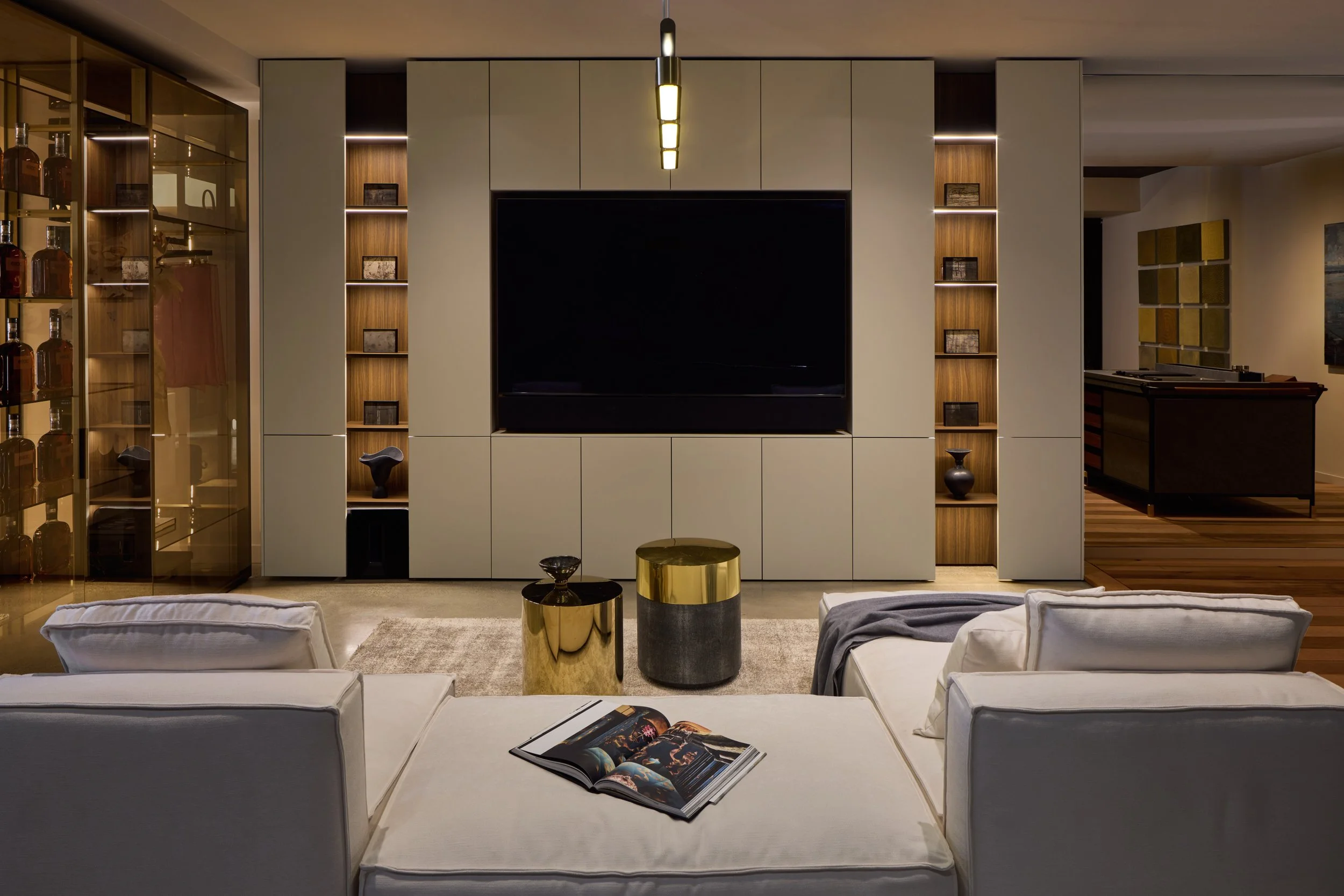 Custom lacquered media wall with walnut open shelving and integrated lighting — SCIC San Francisco showroom