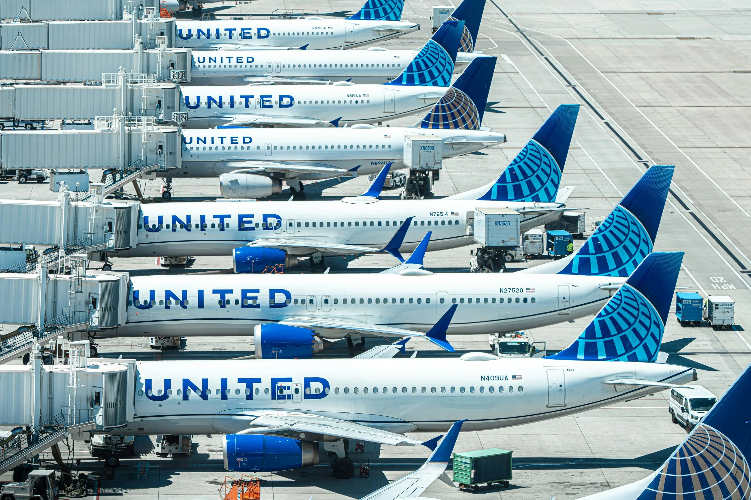 Photo of several United Airlines' aircraft lined up at airport gates