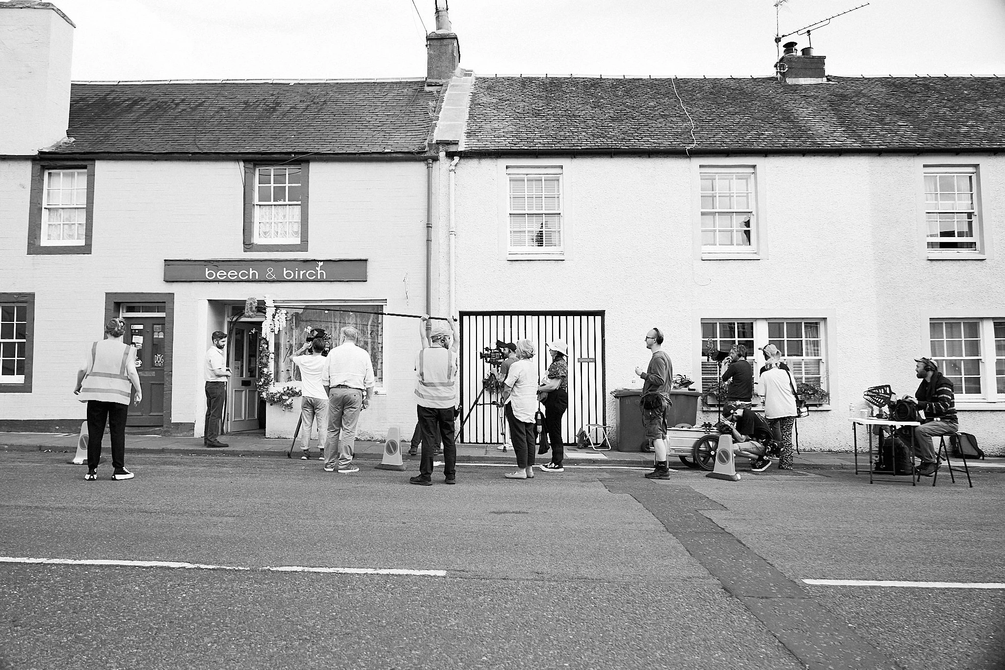 A film crew shooting a scene on location in a Scottish village
