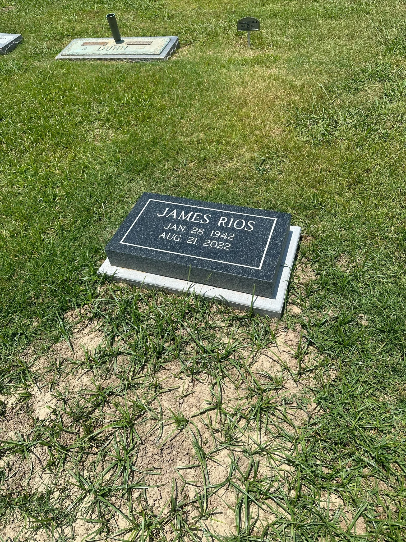 Gravestone for James Rios with birth date January 28, 1942, and death date August 21, 2022, in a grassy cemetery.
