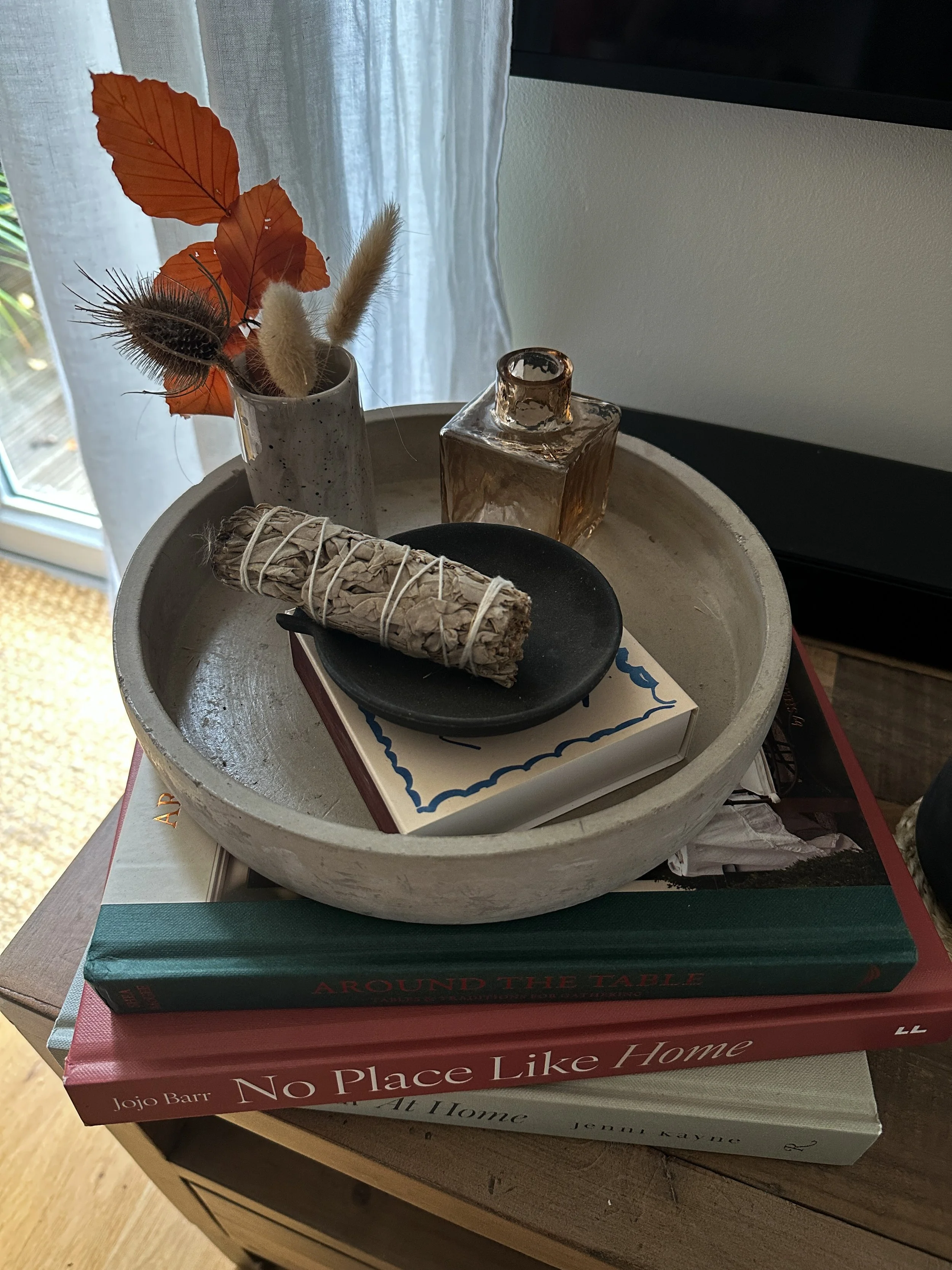 tray with autumn foliage stacked on interiors books