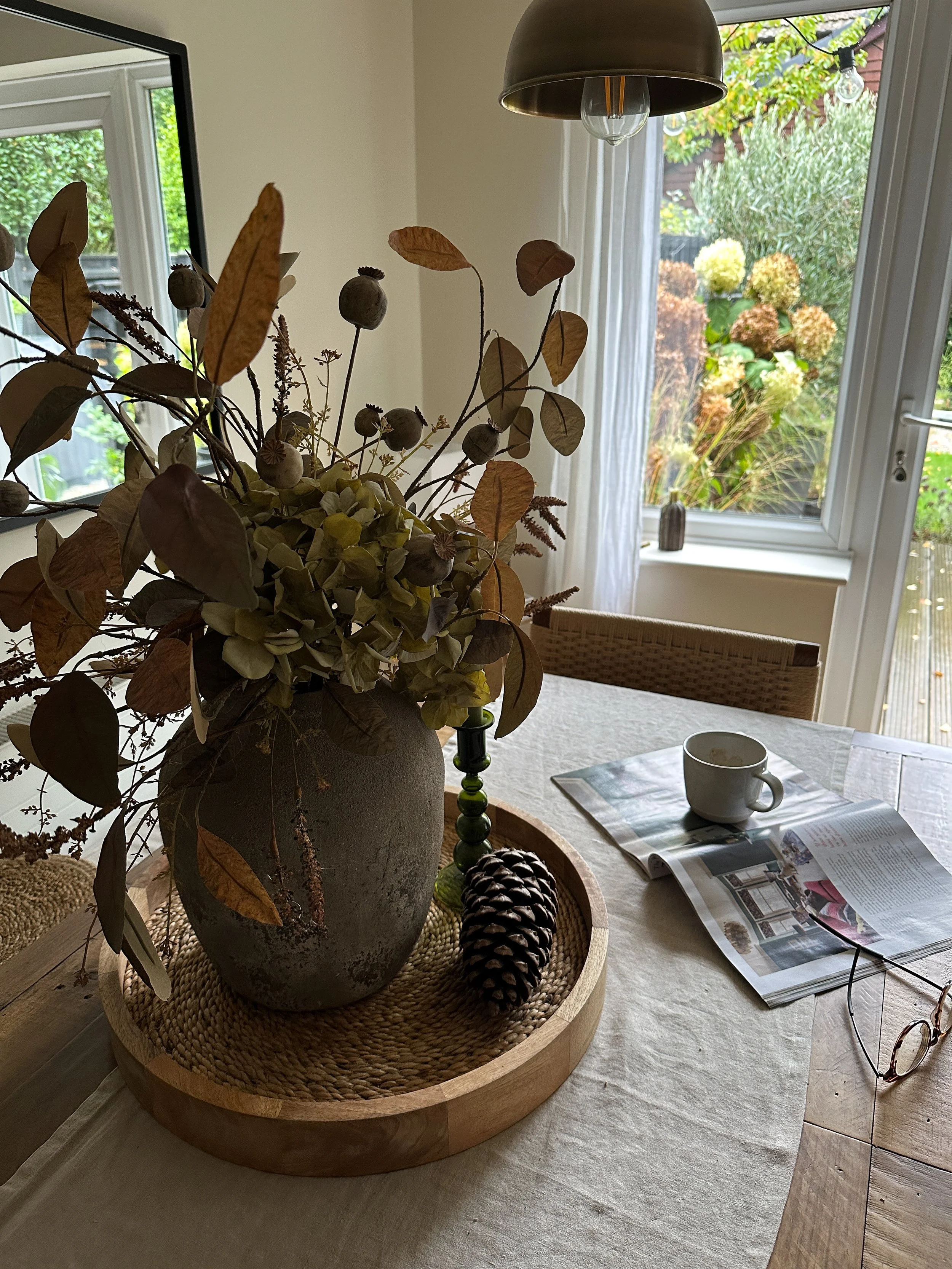 stone vase of faux autumn foliage echoing colours outside