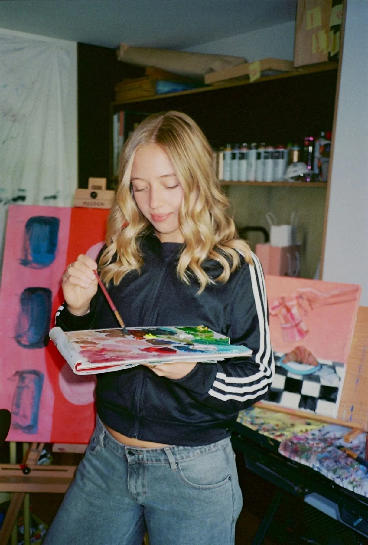 Artist Alexa Kalogeropoulos mixing paints on a pad of paper.