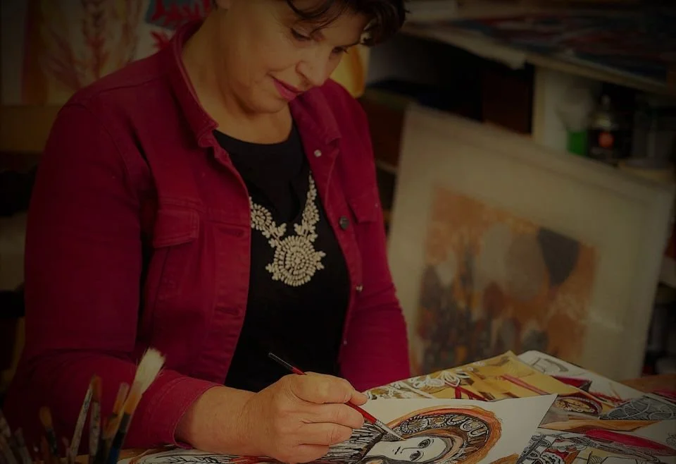 Artist Slavica Zivkovic in a red jacket painting.