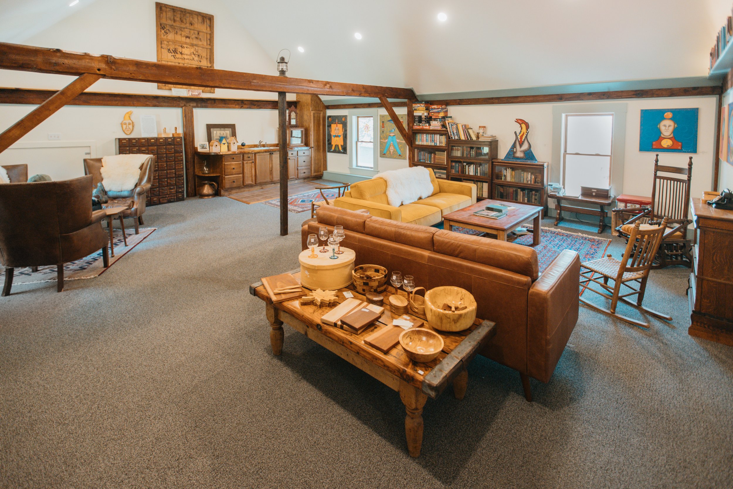 Cozy attic living room with vintage furniture, bookshelves, and colorful artwork.
