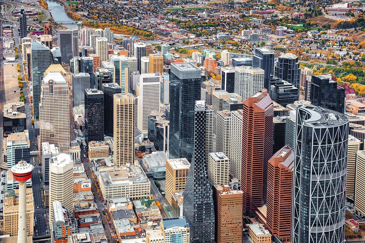 Aerial view of downtown skyscrapers in Chicago with a river in the background and autumn foliage.