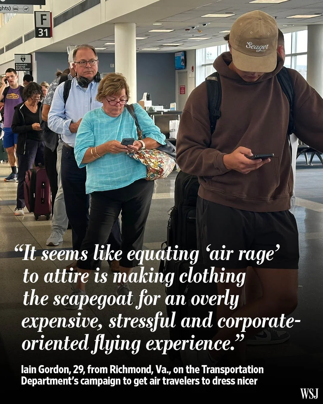 People standing in line at an airport, looking at their phones, with one man wearing headphones and a woman wearing glasses, carrying bags, and a man in a hoodie and shorts in the foreground.