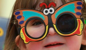 Child wearing colorful butterfly-shaped glasses