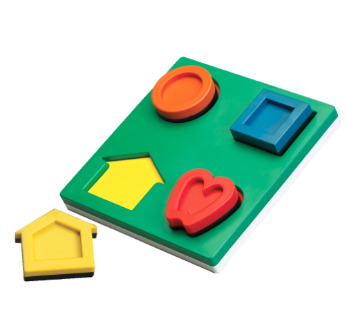 Children's shape puzzle with a green base, featuring a yellow house, red heart, orange circle, and blue square, with the house piece positioned outside its slot.