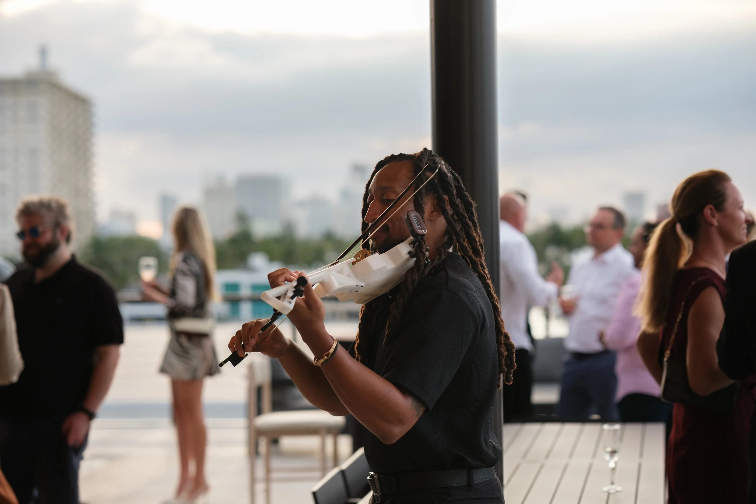 A woman at an art gallery auction listing to live music at an event.