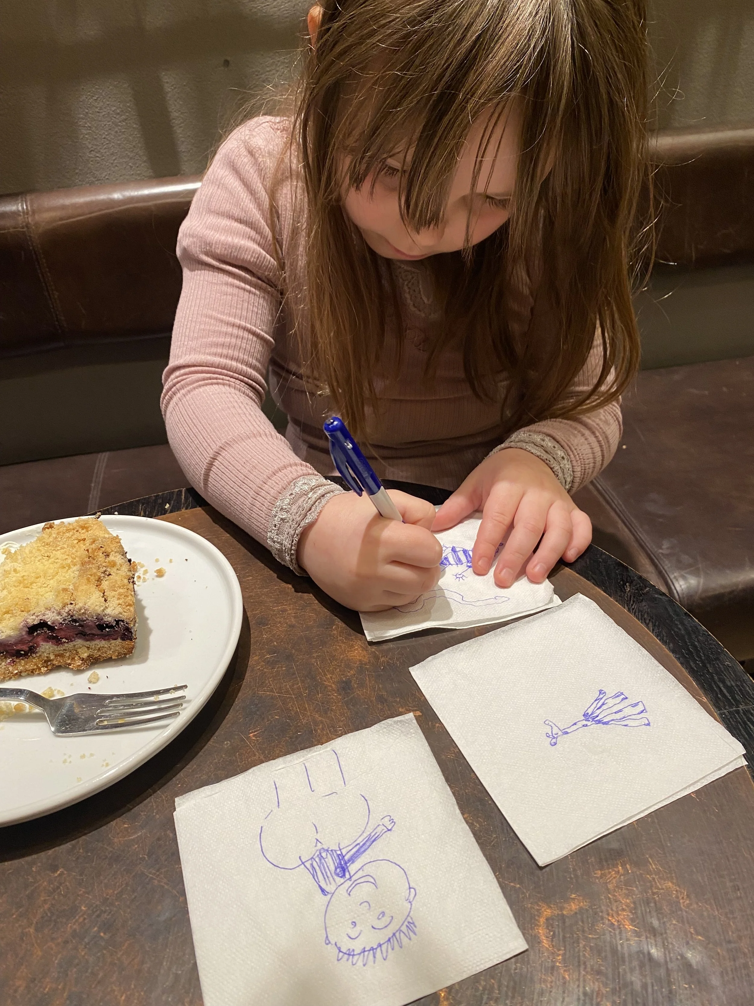 barn sidder og tegner på servietter på cafe på skærmfri onsdag
