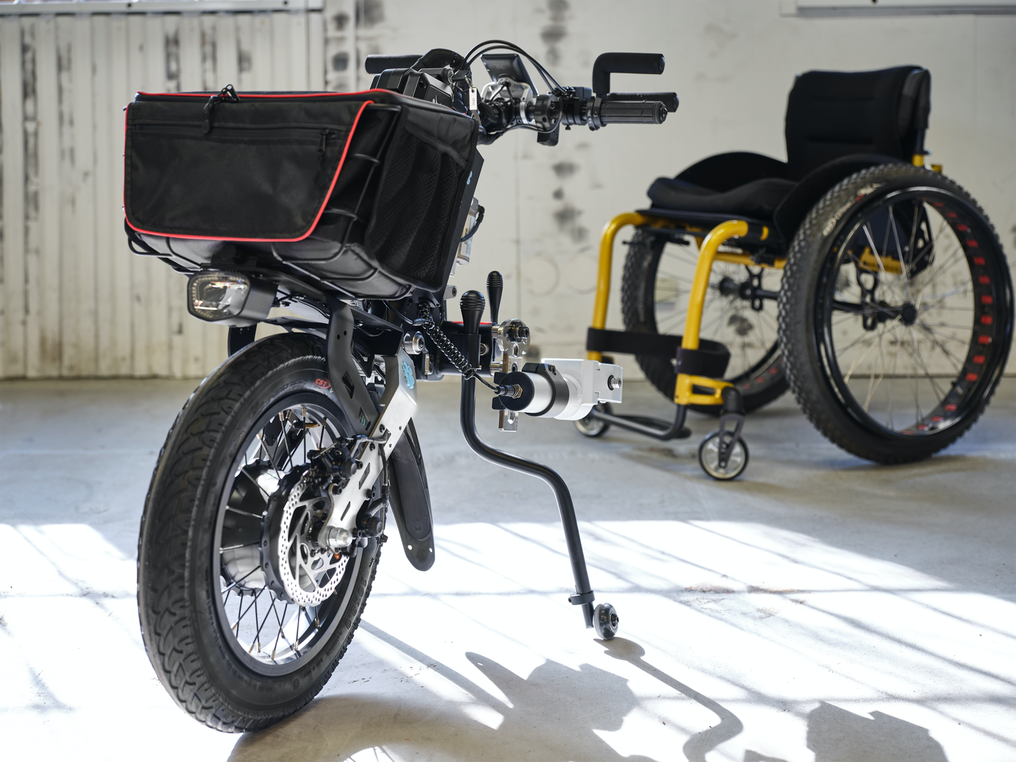 Elektrische quad en rolstoel in een industriële ruimte.