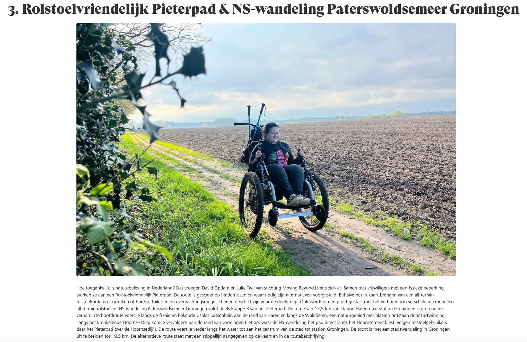 Een persoon in een rolstoel op een zandpad naast een akker, met een helder bewolkte hemel op de achtergrond.