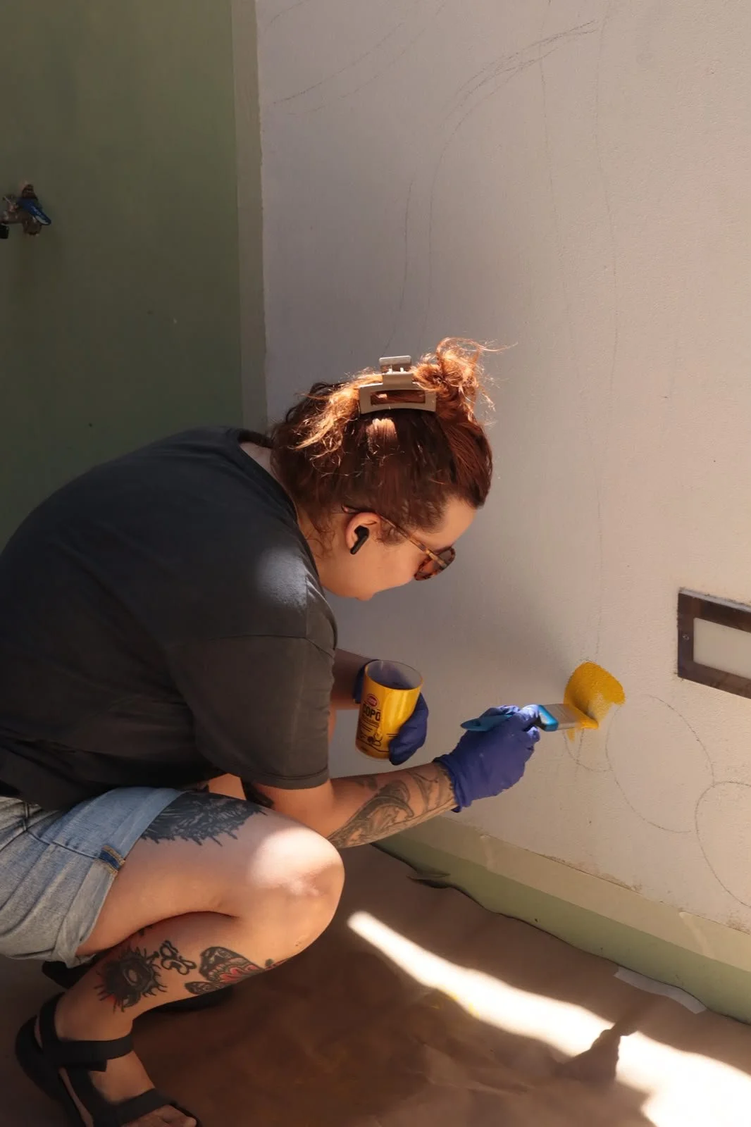 Artist painting a detail of the Peloton Café mural