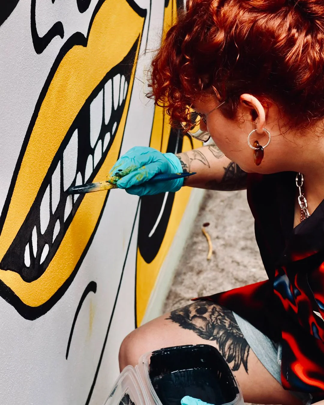 Close-up of the artist finishing a detail of the Peloton Café mural