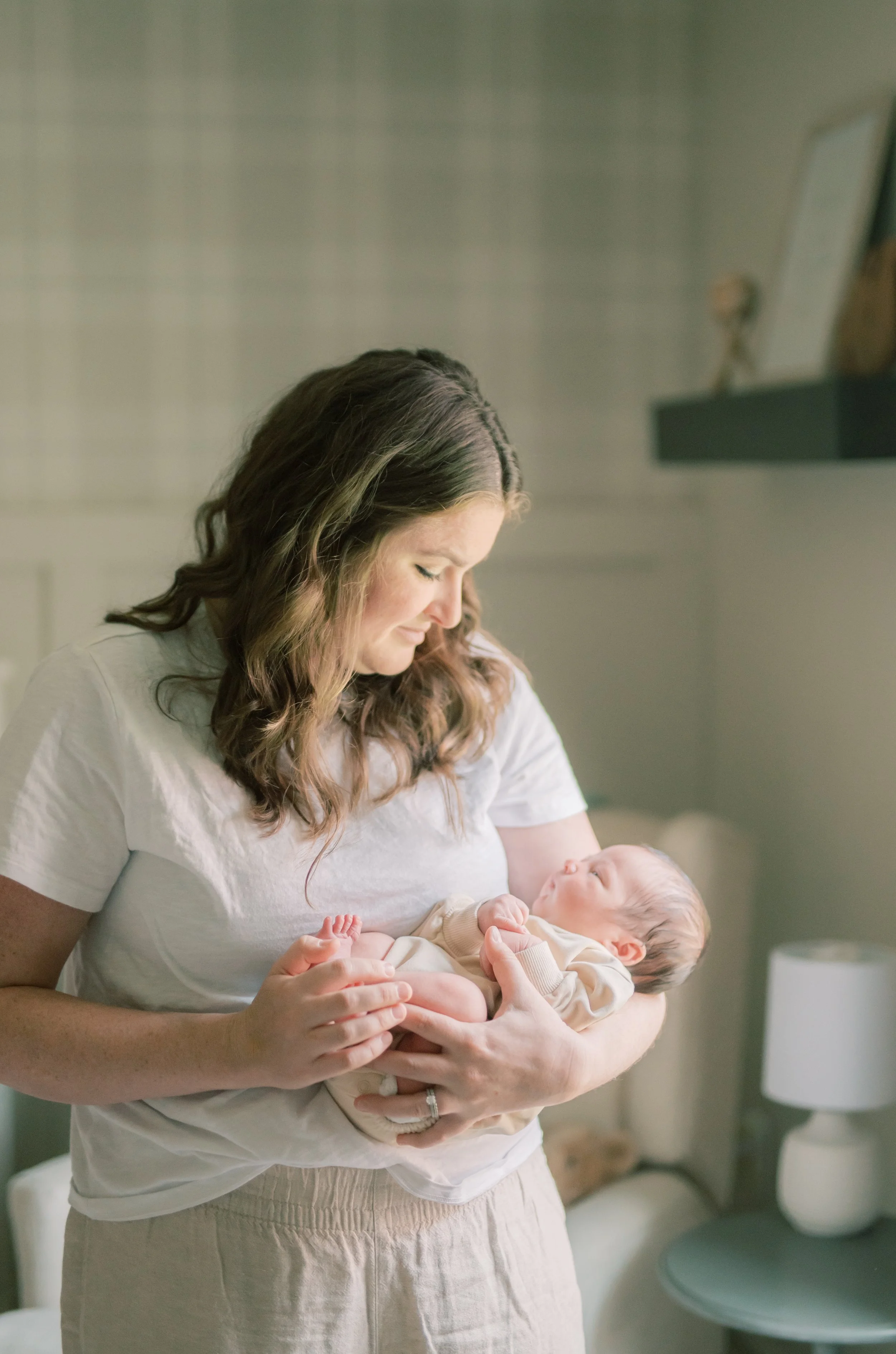 Mother holding her newborn baby during a lifestyle newborn photo session
