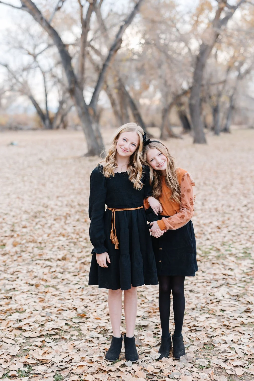 Sibling photography capturing the sweet, playful connection between sisters in a beautiful outdoor fall setting. This St. George children’s portrait session creates timeless images filled with genuine personality, natural emotion, and the special bon