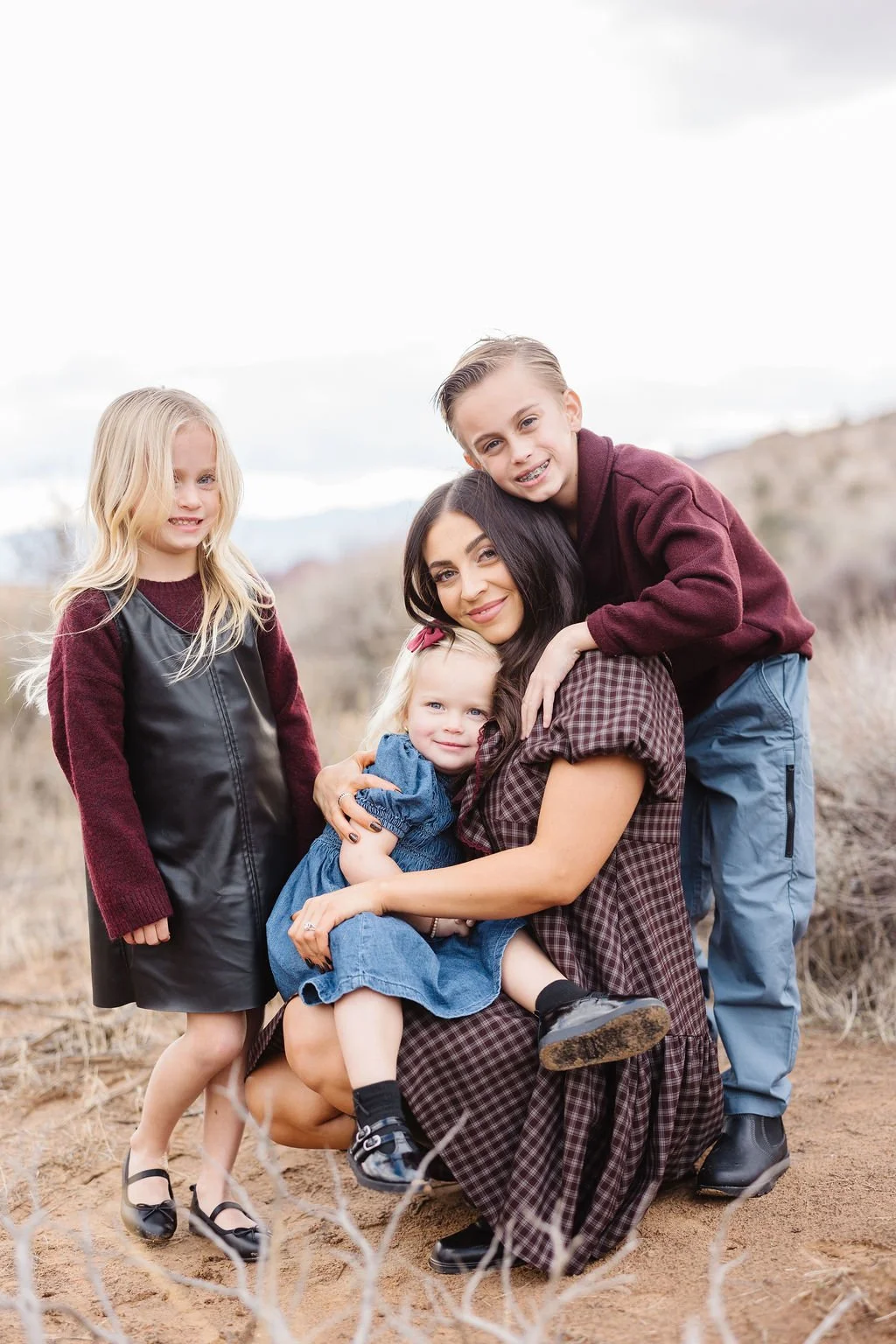 Lifestyle family photography capturing a mother and her children sharing a joyful, candid moment in the natural landscapes of Southern Utah. This St. George family photoshoot celebrates genuine connection, playful personalities, and timeless memories