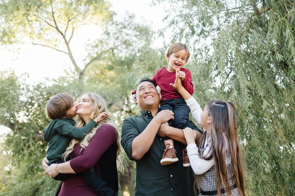 Lifestyle family photography capturing joyful, authentic connection between parents and children in a natural outdoor setting. This St. George family photoshoot highlights genuine laughter, playful moments, and the unique personalities that make ever